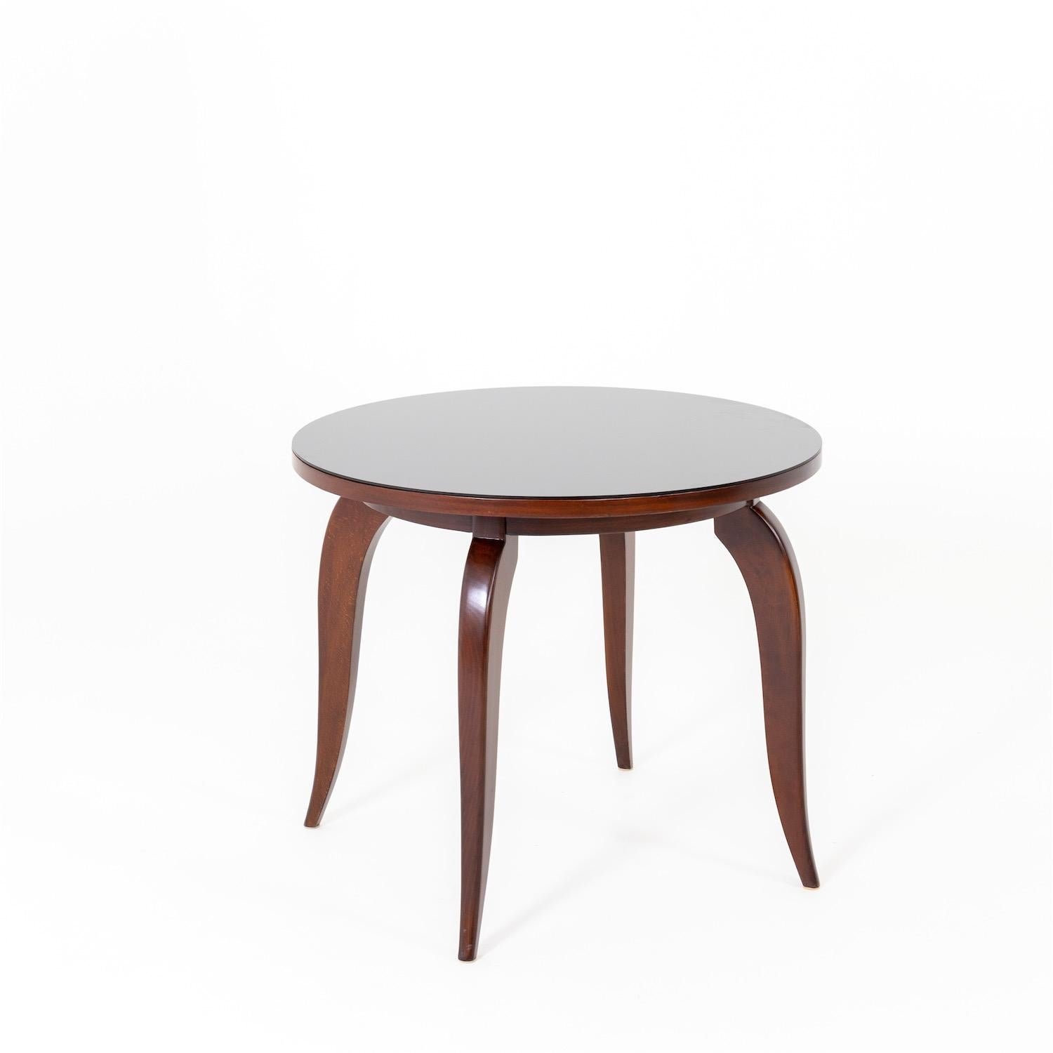 Round Art Deco table on curved elegant legs made of stained beech. The tabletop is protected with a glass pane. Professionally refurbished condition.