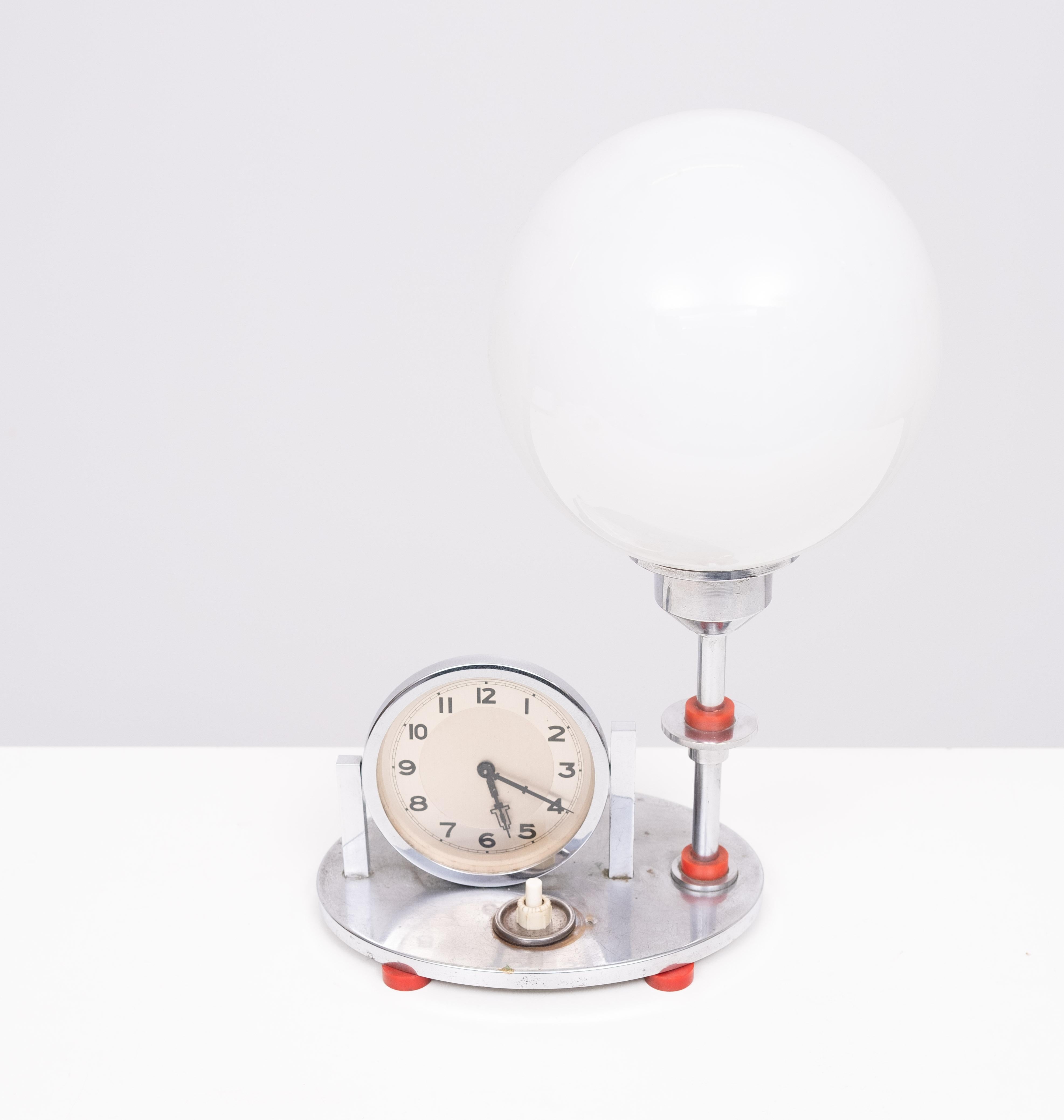 Very nice Art Deco table Clock Lamp .Chrome with Red 
details . Good working Clock and lamp 