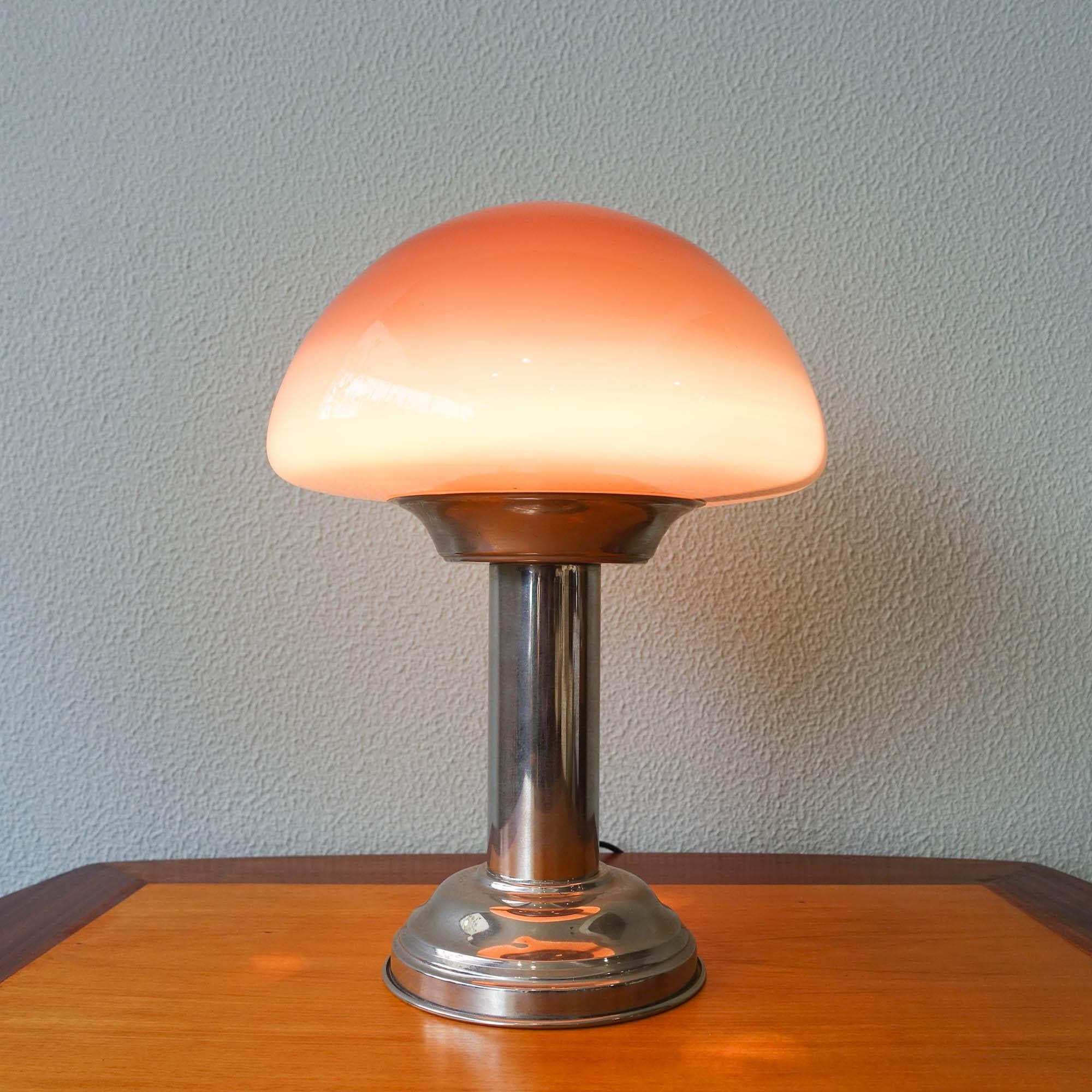 This table lamp was produced in Portugal, during the 1930's. The base is made of chrome brass in a cylindrical shape where an purple opaline mushroom shaped glass shade is set. It is in the original and good condition.