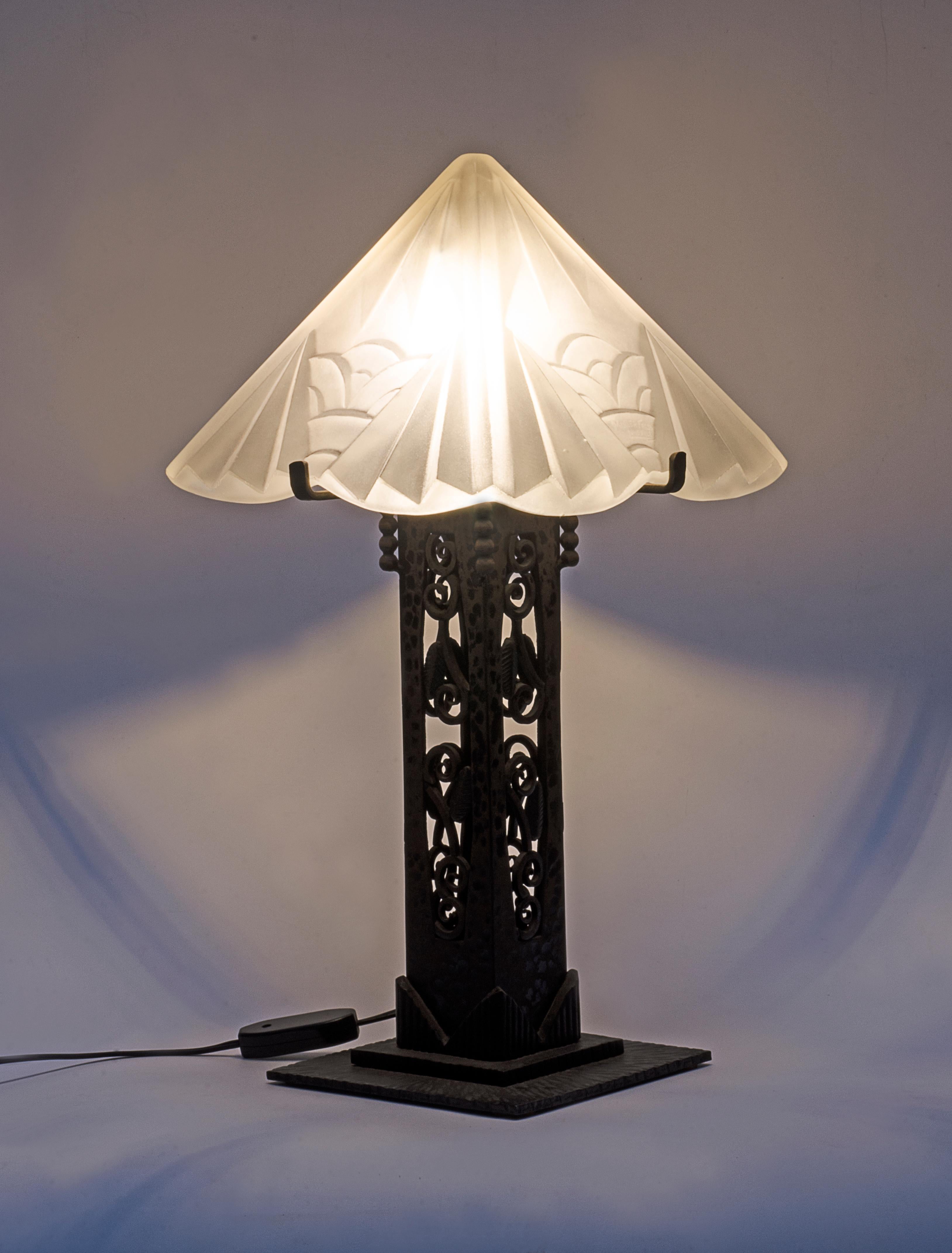 Art Deco Tischlampe aus schwarz patiniertem Eisen mit satiniertem Glasschirm, von Muller Freres Glass (1858-1959). Ursprünglich unter dem Namen Croismare bekannt, wurde das Design 1895 von den Gebrüdern Muller übernommen, und die Marke Muller Freres