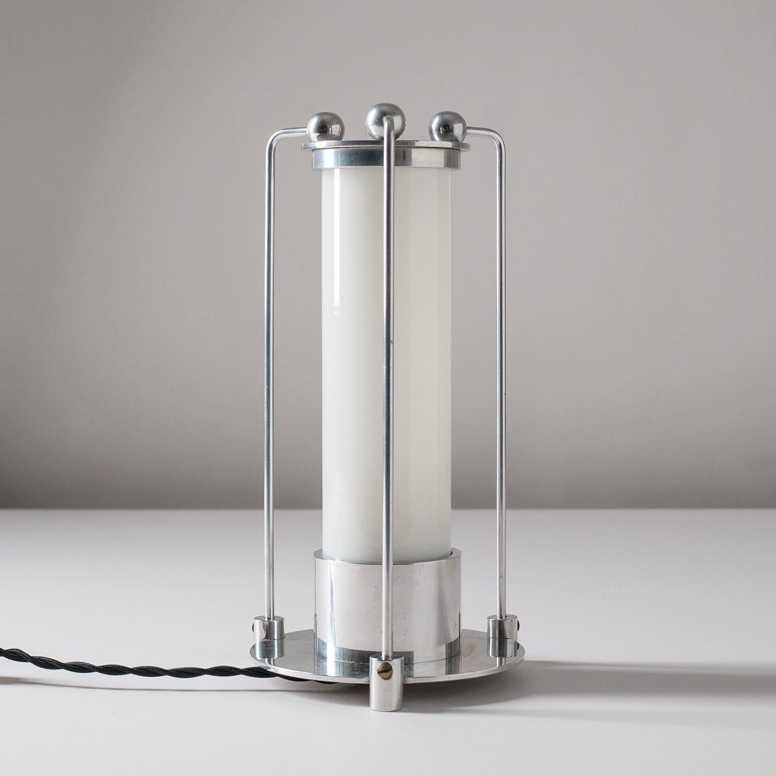Rare Art Deco table lamp, from the 1930s. Very unique Minimalist, Bauhaus-influenced, design with a polished aluminum body construction and a blown opaline or milk glass tube. Very nice original condition with a light patina on the aluminum. One