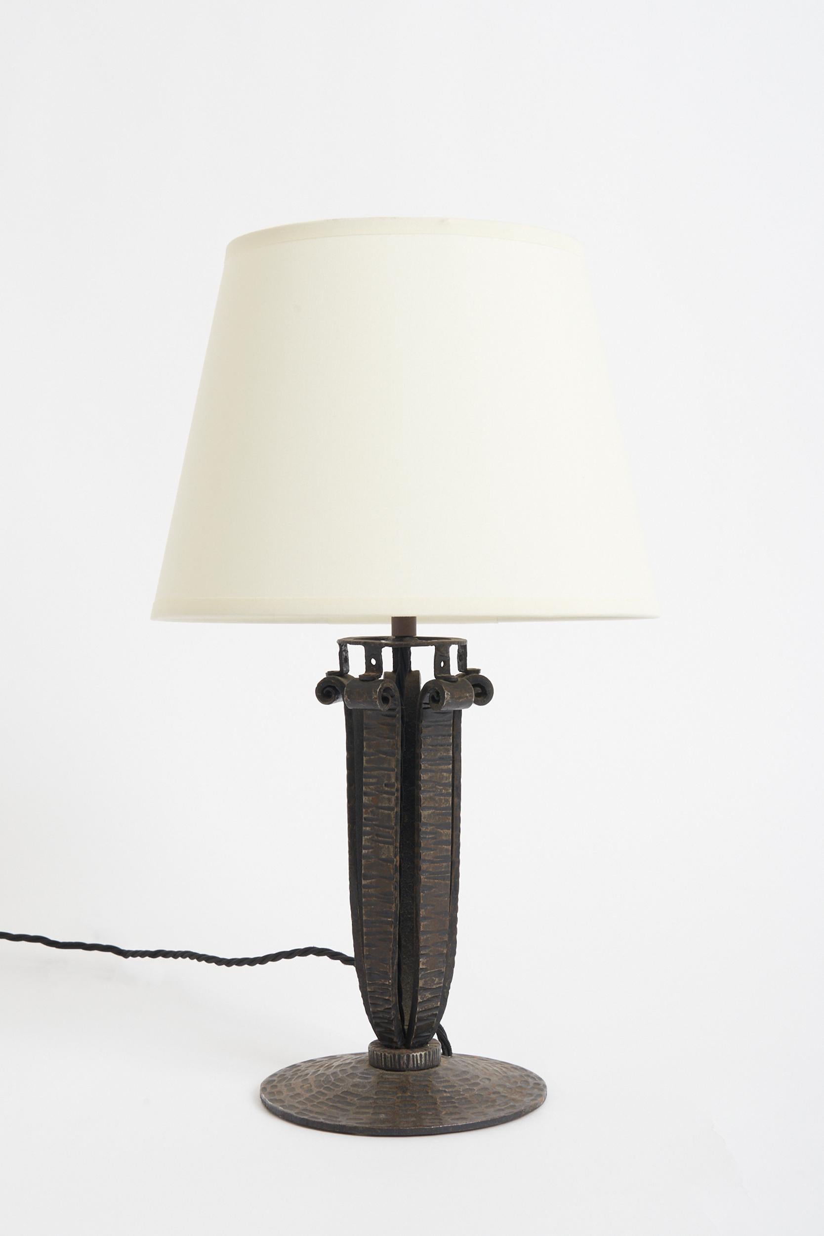 An Art Deco wrought iron table lamp
France, circa 1930
With the shade: 41.5 cm high by 25.5 cm diameter 
Lamp base only: 29 cm high by 16 cm diameter.