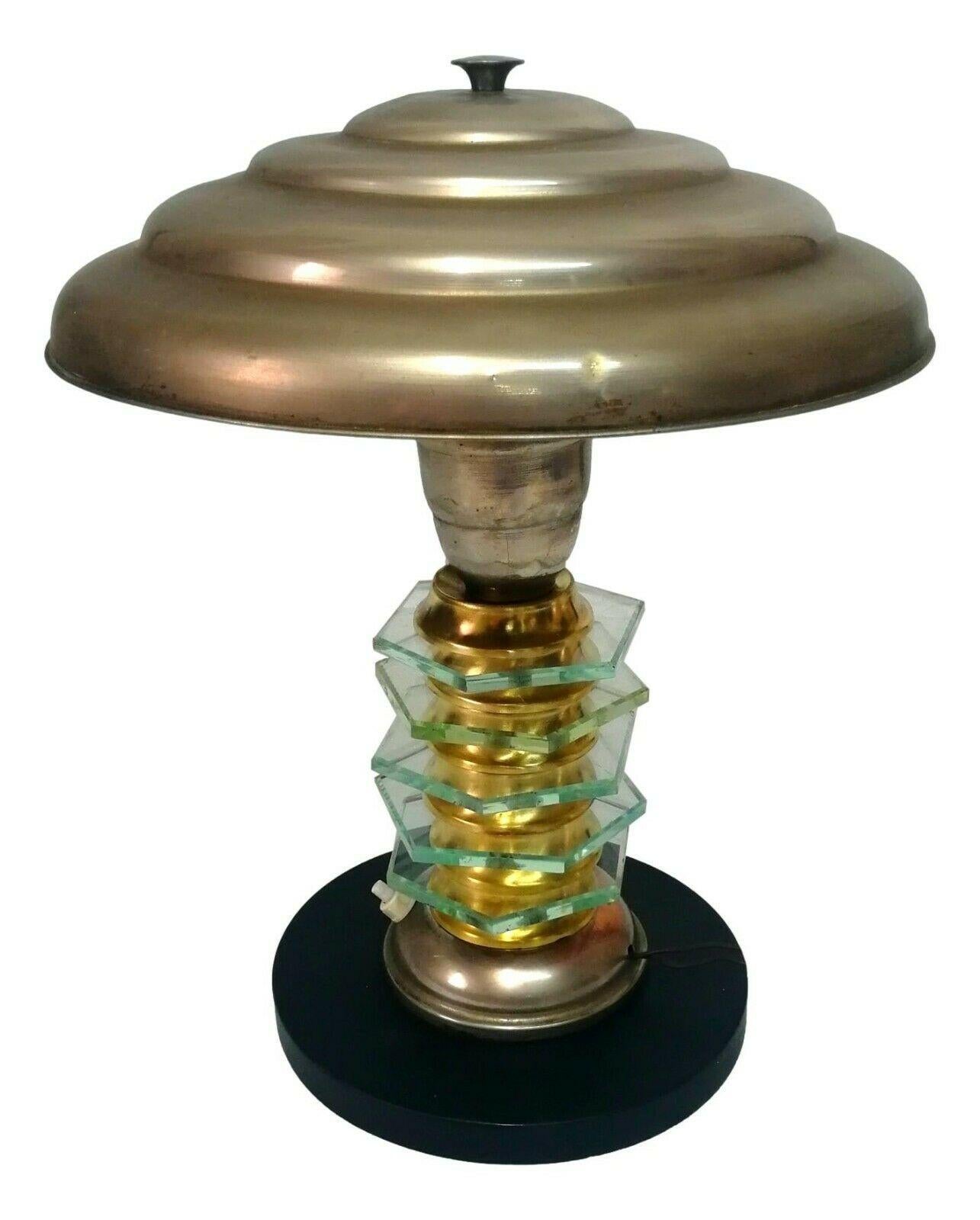 splendid art decò table lamp, original from the 50s, made with an aluminum hat, central body in brass and crystal worked in hexagons, base in black lacquered wood

It measures 36 cm in height, 30 cm in diameter at the top and 18 cm in diameter at