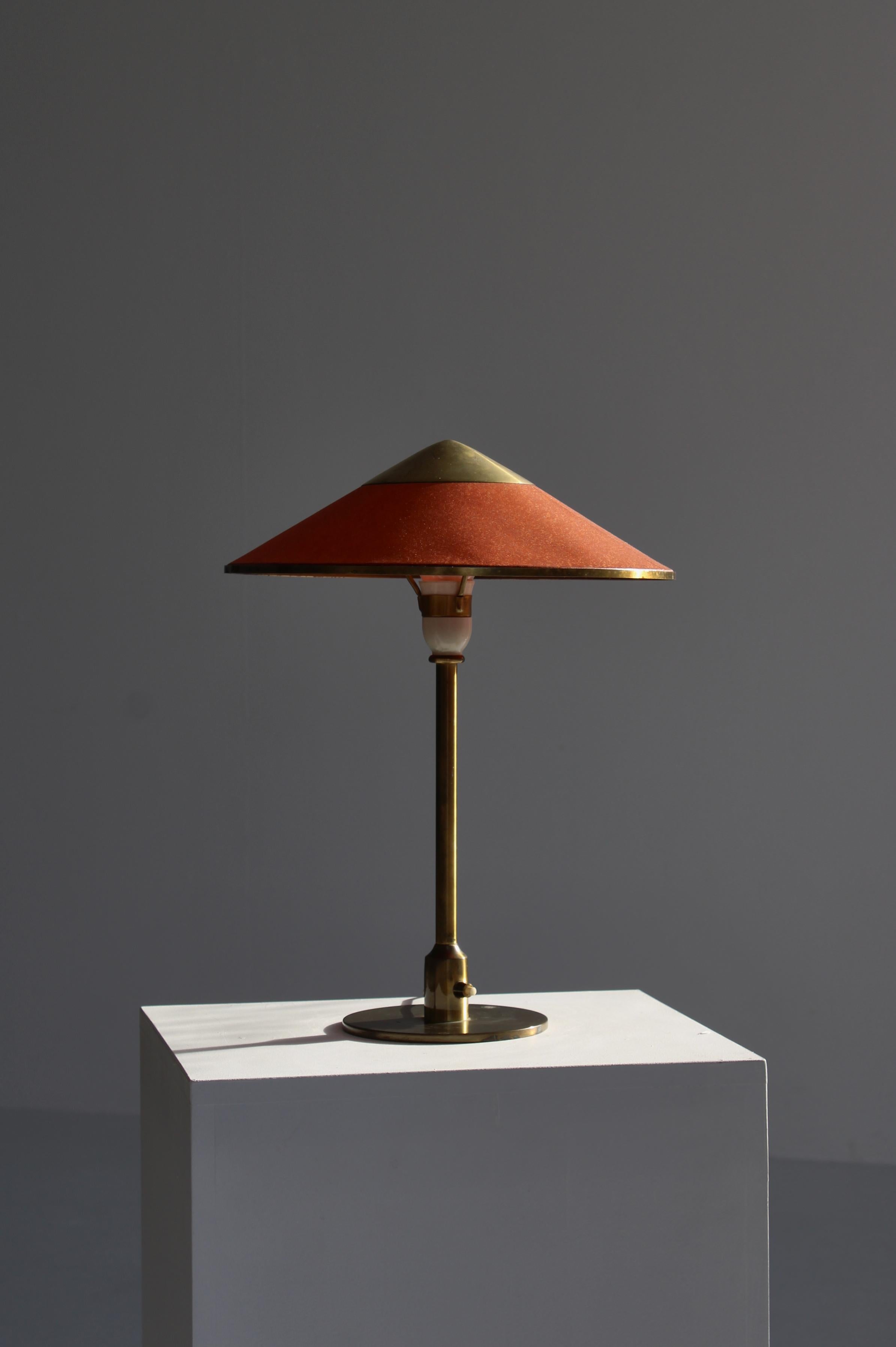 Art Deco table lamp from the 1930s in beautifully patinated brass and burned red oiled paper shade. The lamp was designed by Danish Sculptor Niels Rasmussen Thykier in 1930 and was made by Fog & Mørup, Copenhagen from 1936 and onwards. The lamp was