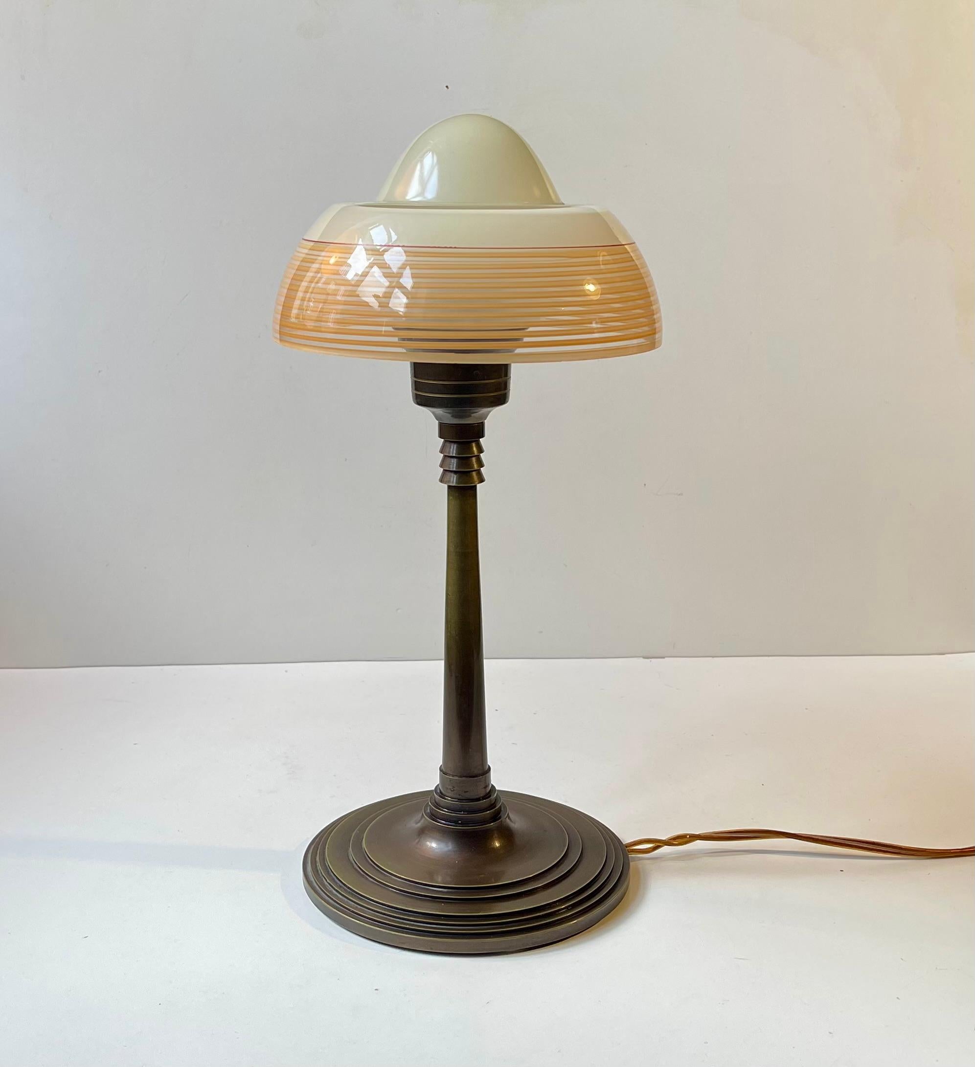 Lámpara de escritorio de estilo Art Déco fabricada por Fog & Mørup en la década de 1930. Presenta una base y una varilla de bronce patinado, ambas con características arquitectónicas 