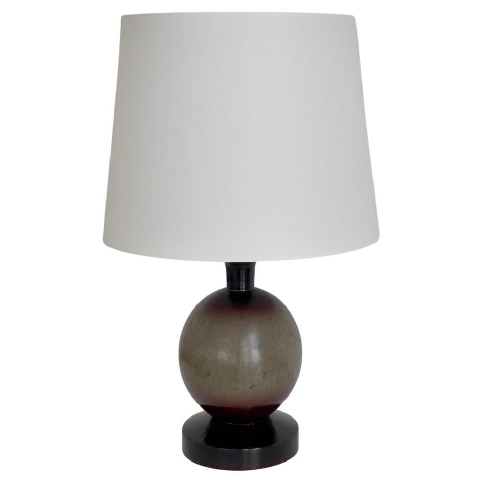 Lampe de table danoise évocatrice des années 1920, fabriquée en bois et ornée d'une finition délicatement exécutée en faux marbre dans des tons doux de vert et de violet, aujourd'hui légèrement décolorés. La base en bois tourné révèle un jeu