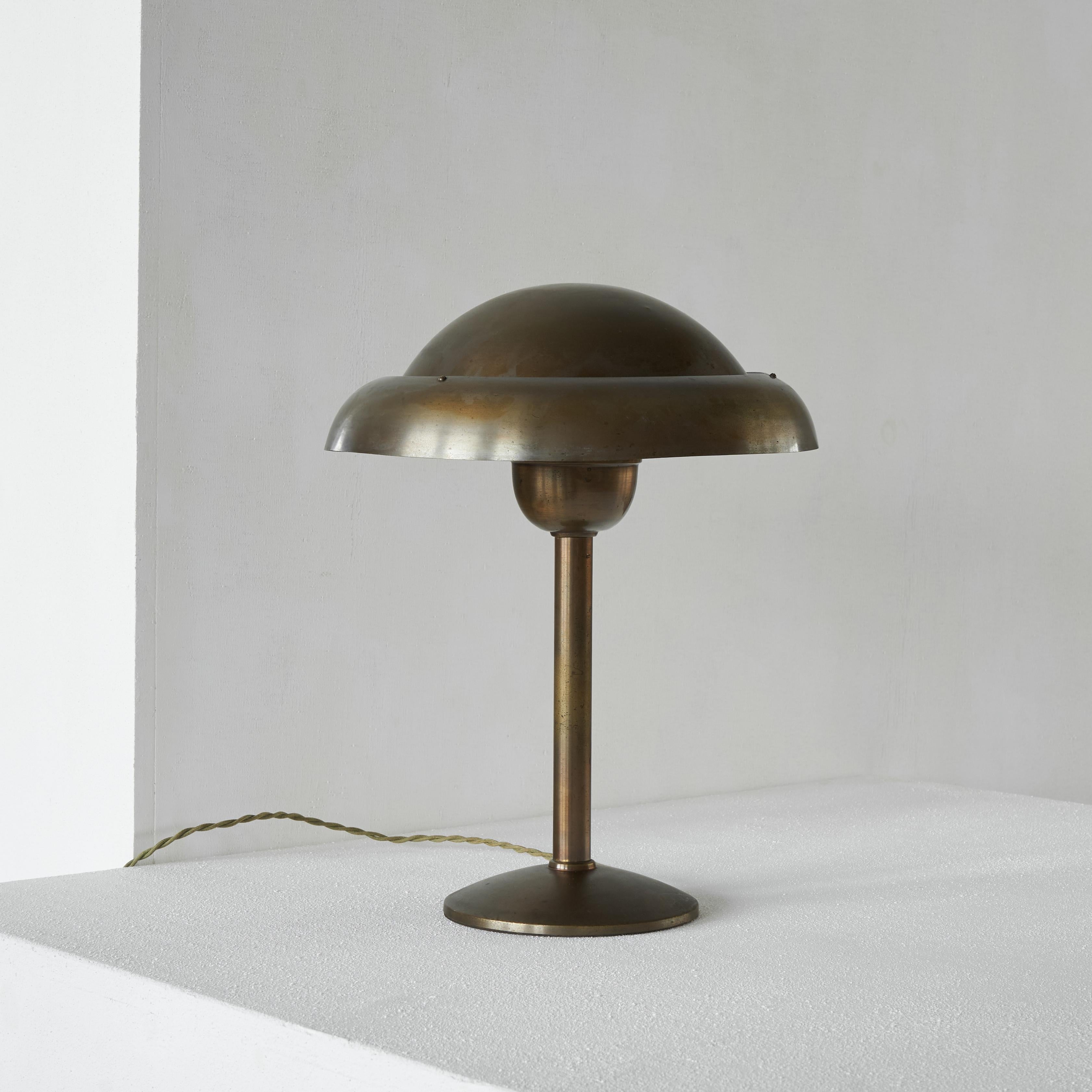 Art Deco table lamp in patinated brass. First half of the 20th century. 

Wonderful and rare table lamp in a distinct art deco style. The shape is simple, but interesting at the same time. Due to the double top shade, the light also comes out at