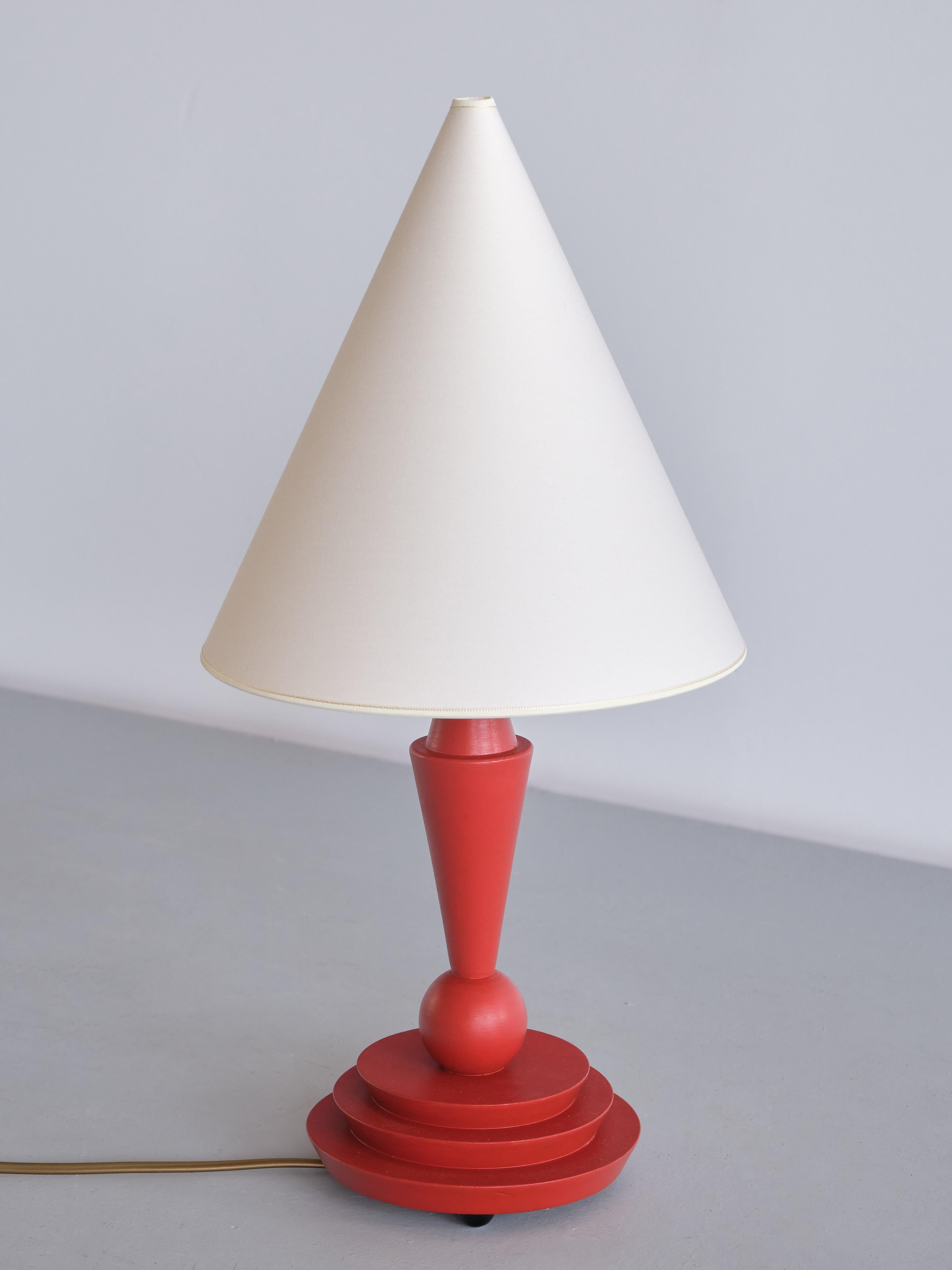 This striking Art Deco table lamp was produced in Austria in the late 1930s. The design is marked by the elegant shape of the beech base which has been finished in a vermilion (red/orange) lacquer. The lamp consists of a three tiered circular base,