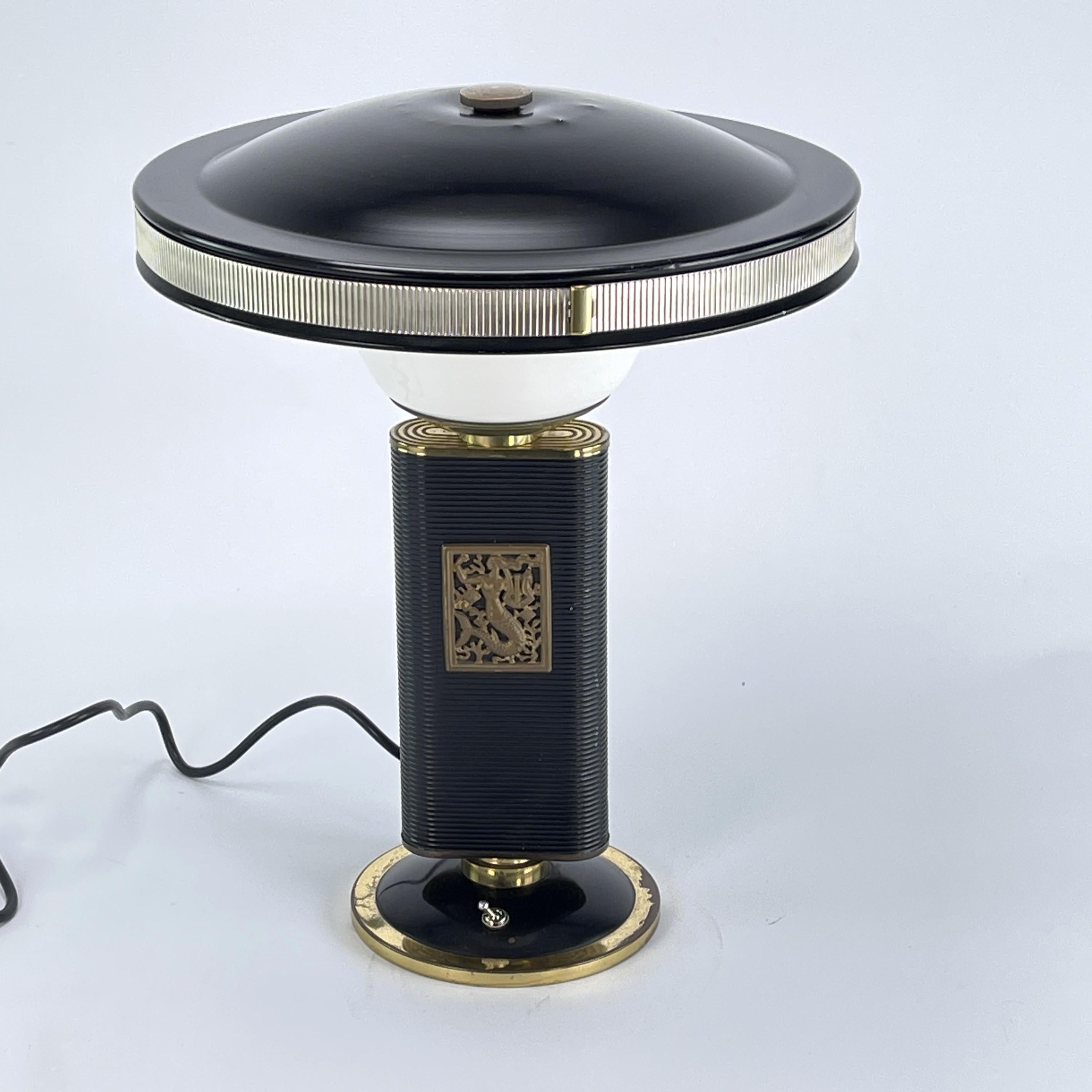 Art Deco table lamp from Eileen Gray - Siren

This stunning Art Deco lamp from the 1950s is an outstanding example of the elegance and sophistication of the Art Deco style. With its combination of brass and plastic, this table lamp embodies the