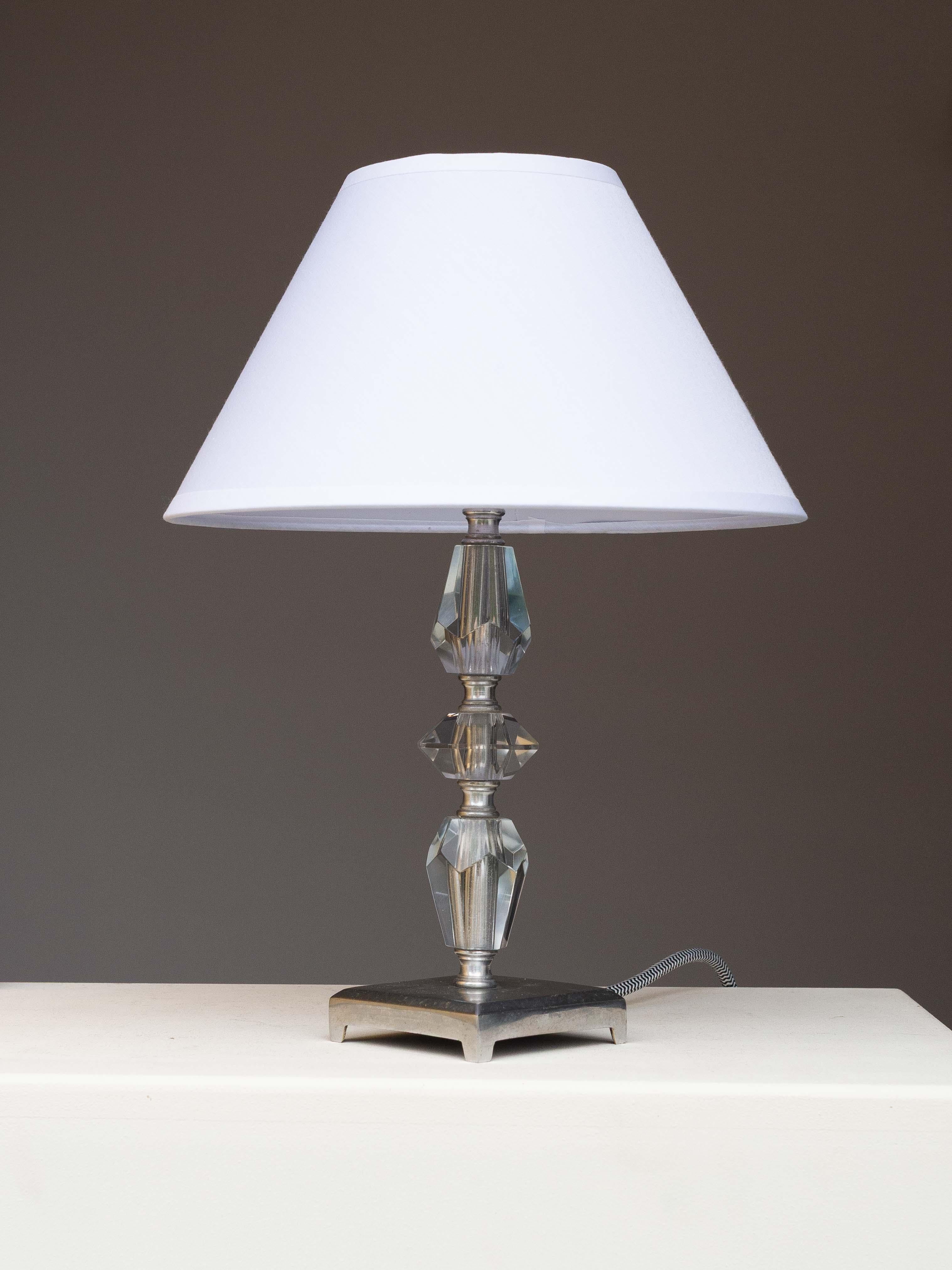 Art Deco Table lamp - Modernist Lamp - Crystal & Stainless Steel, France 1940s

Elegant table lamp, crafted in France in the 1940s.

Combining cut crystal geometric shapes with stainless steel. 

The crystal base captures and reflects the light