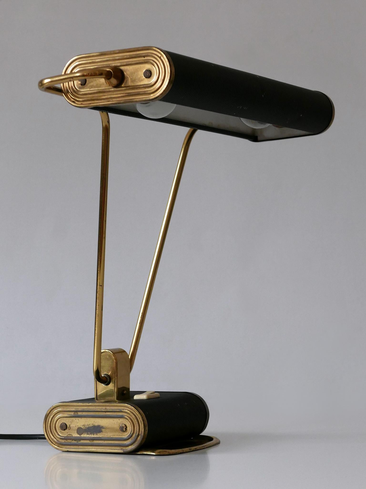 Elégante lampe de table ou de bureau Art Deco n° 71. Abat-jour rotatif. Conçu par André Mounique pour Jumo, France, années 1930.

Un total de 5 lampes en deux couleurs est disponible !
Il s'agit du numéro 1 des cinq lampes de bureau. Les images sont