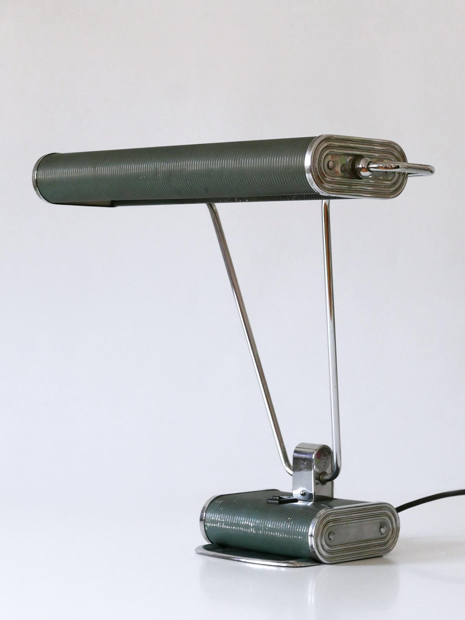 Elegante lampe de table ou de bureau Art Deco 'No 71' de couleur bleu-gris et argent. Abat-jour rotatif. Conçu par André Mounique pour Jumo, France, années 1930.

Un total de 5 lampes en deux couleurs est disponible !
Il s'agit du numéro 5 des cinq