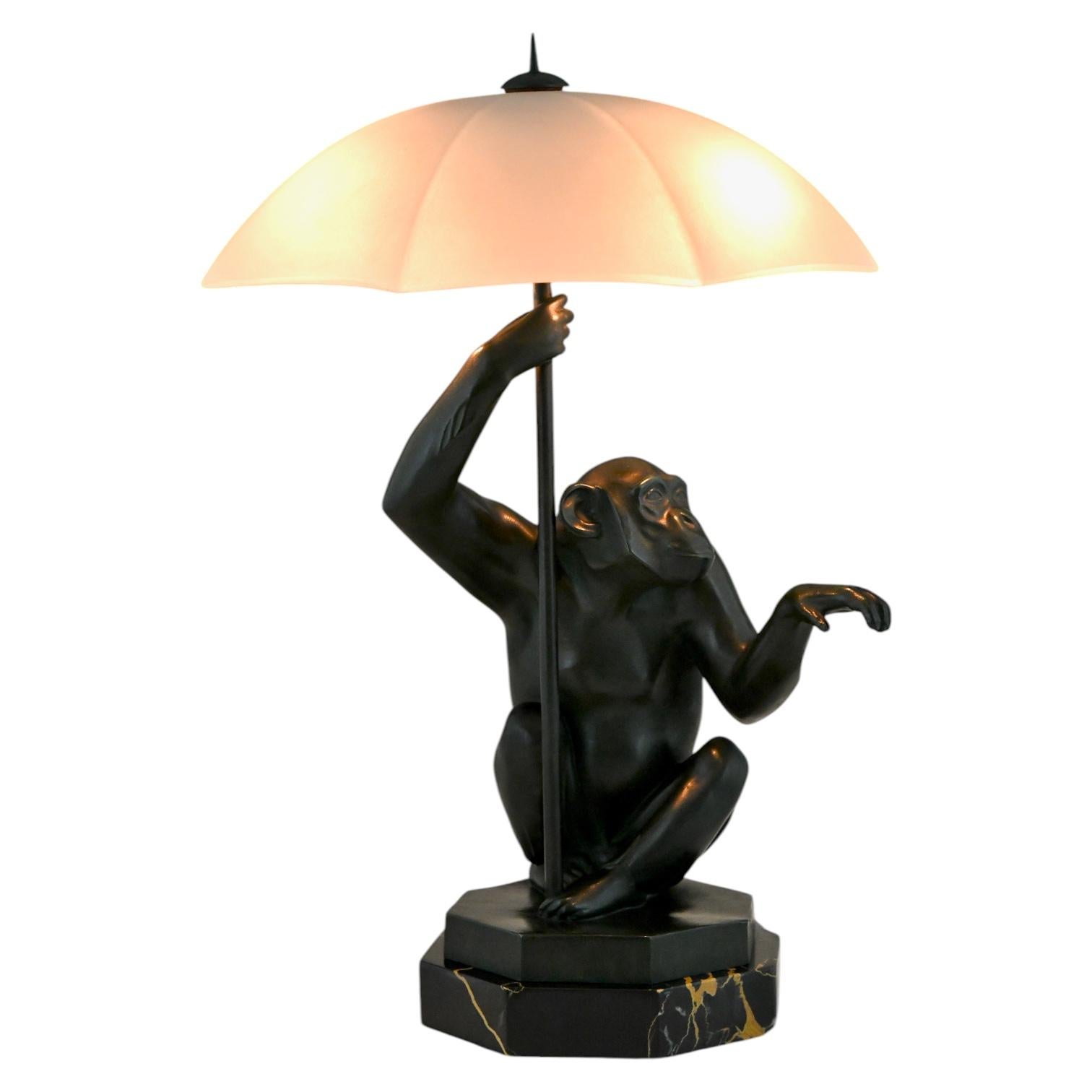 Art Deco lamp monkey with umbrella PLUIE by Max Le Verrier. 
Patinated metal on Portor marble base, frosted glass umbrella shade. 
France 1927. 
Le Verrier foundry seal. 
With certificate of authenticity. 

History about the lamp with monkey :
It