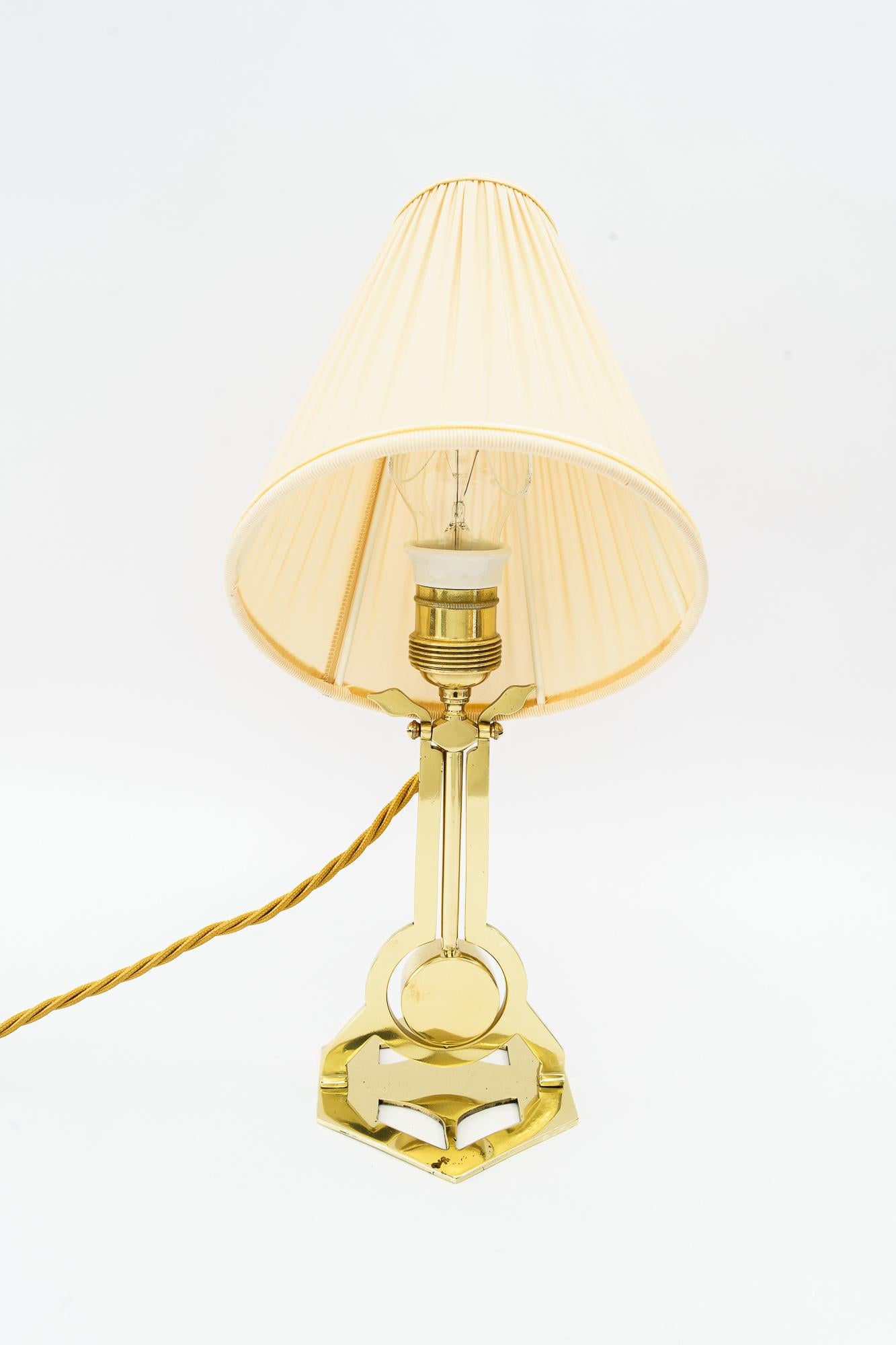 Art Deco table lamp vienna with fabric shade around 1920s 
Brass polishged and stove enameled
The fabric shade is replaced  ( new )