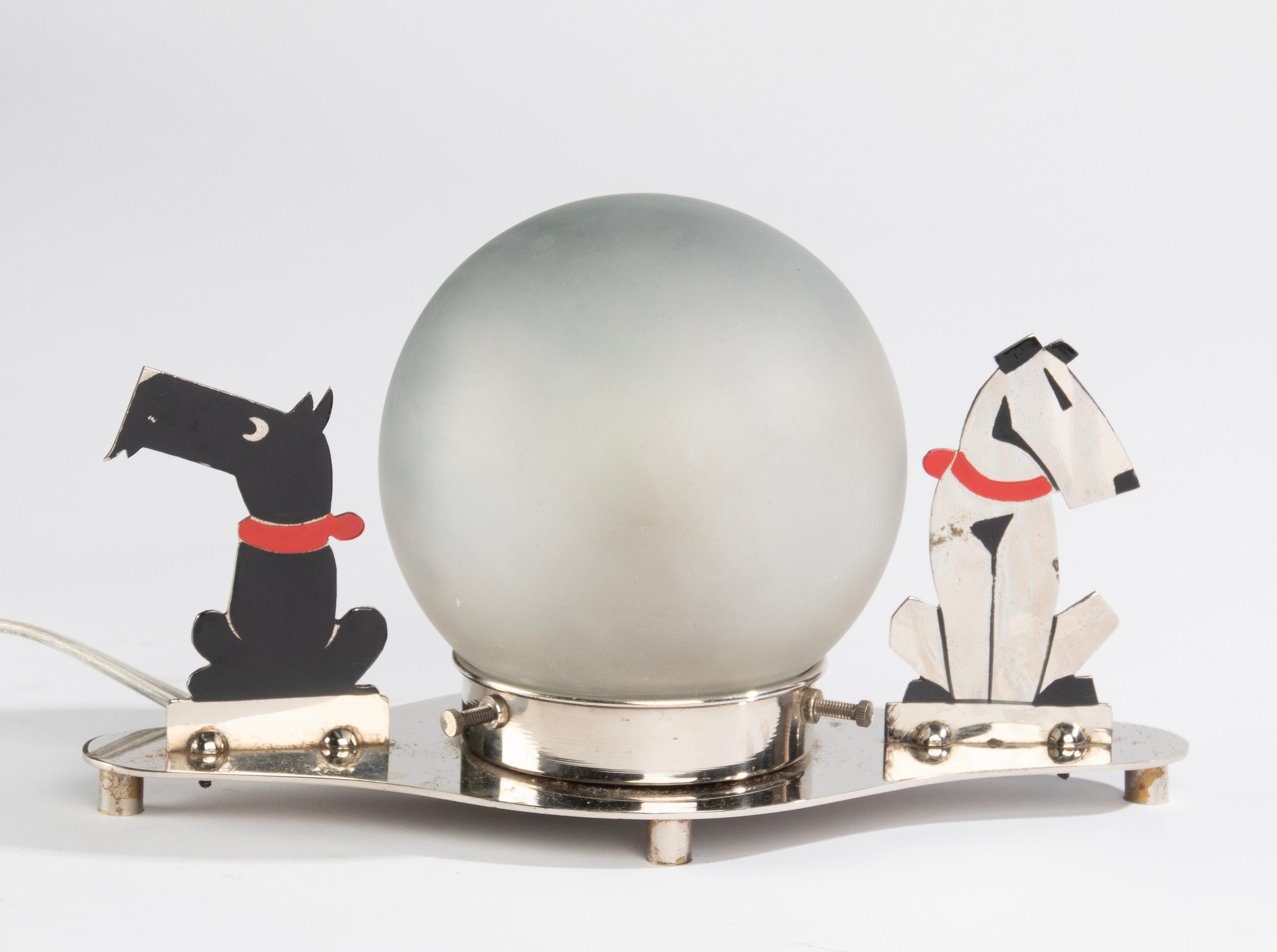 A lovely Art Deco table lamp, flanked by two dogs (black and white). 
Made of chrome plated metal. The lampshade is made of satined glass. 
The lamp is in good and working condition. Rewired, with switch and EU plug.
Dimensions: 25 x 12 cm and 15 cm