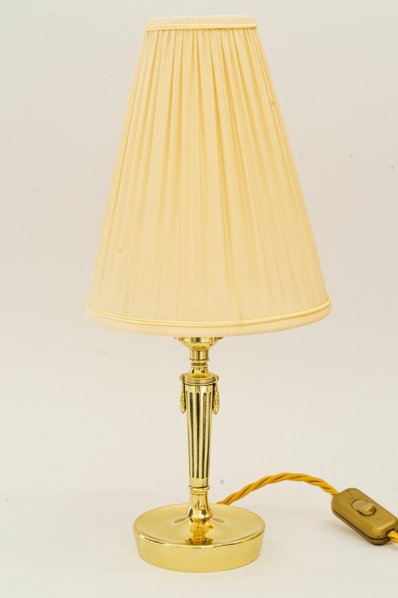 Art-Déco-Tischlampe mit Stoffschirm Vienna aus den 1920er Jahren
Messing poliert und emailliert
Der Stoffschirm wird ersetzt ( neu )
