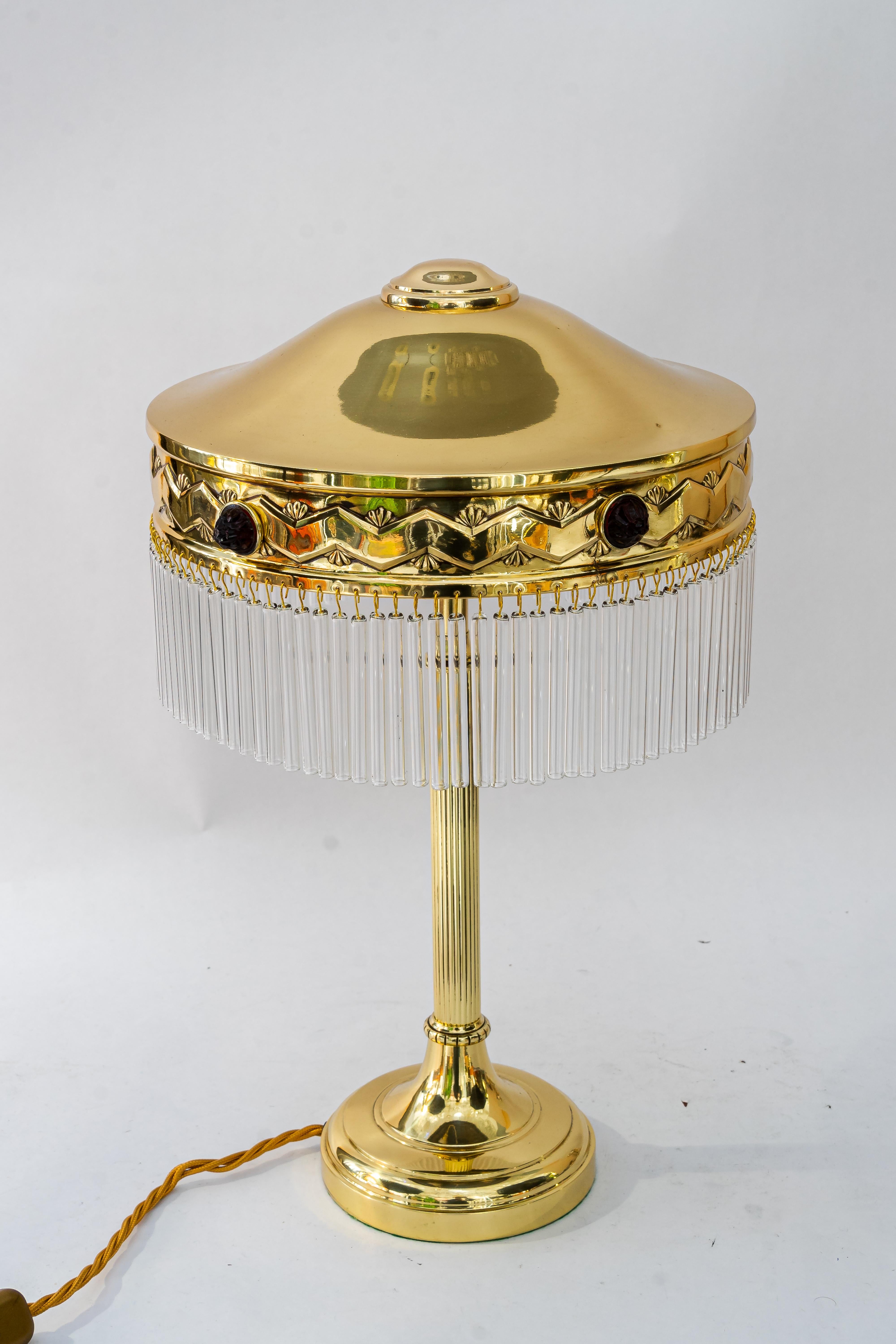 Lampe de table Art déco avec abat-jour en verre opalin rouge et bâtons en verre des années 1920
Les bâtons de verre sont remplacés (neufs).
Laiton poli et émaillé au four