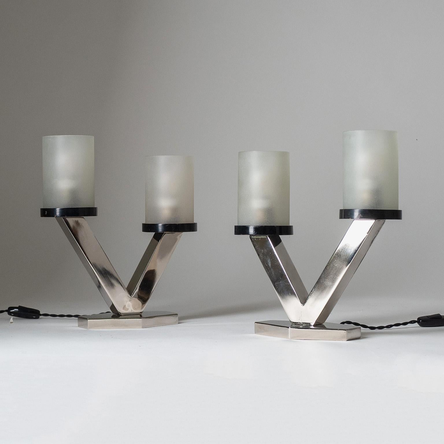 Rare pair of nickeled Art Deco table lamps with frosted glass diffusers from the 1920s. Clean geometric design with a nice asymmetric touch. Nickeled steel base with two asymmetric arms, each holding a lacquered wood disc which supports a thick