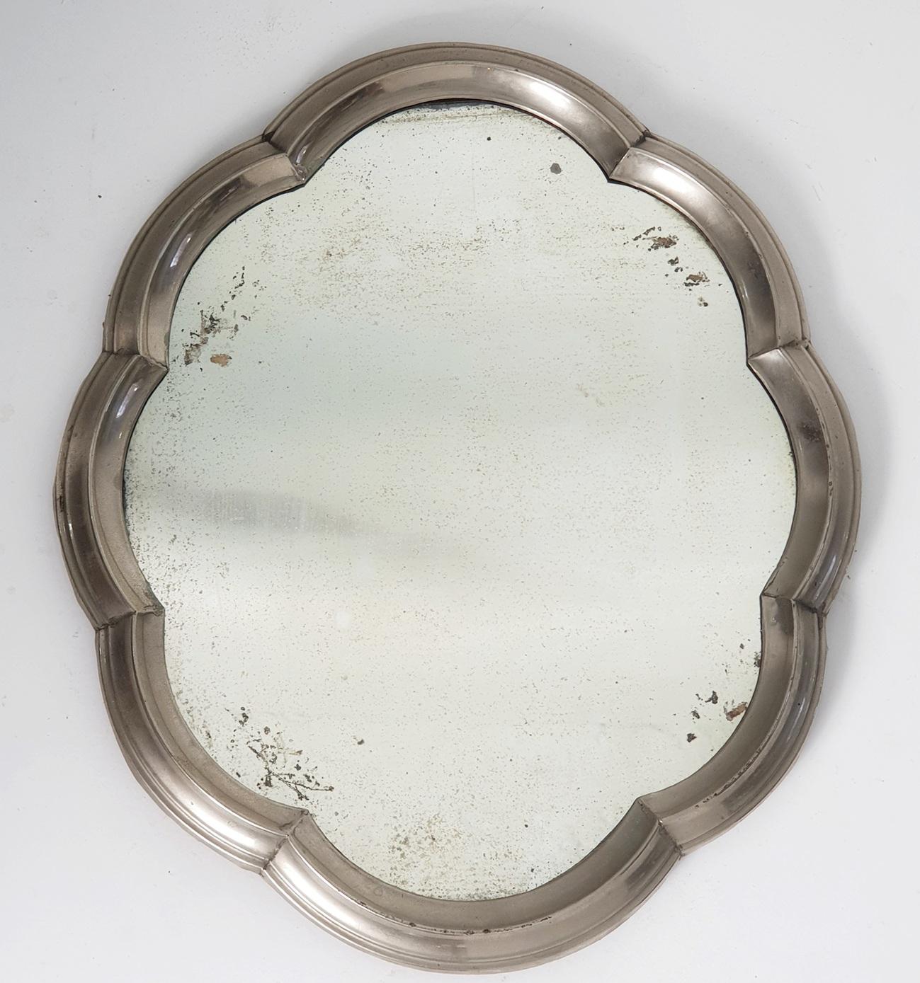 This is a unusual mirror made for decorating the table. The mirror is made with a frame in pewter in baroque style and with the original mirror glass still in place. It stands on small feet giving a bit of height from the table. The glass has beauty