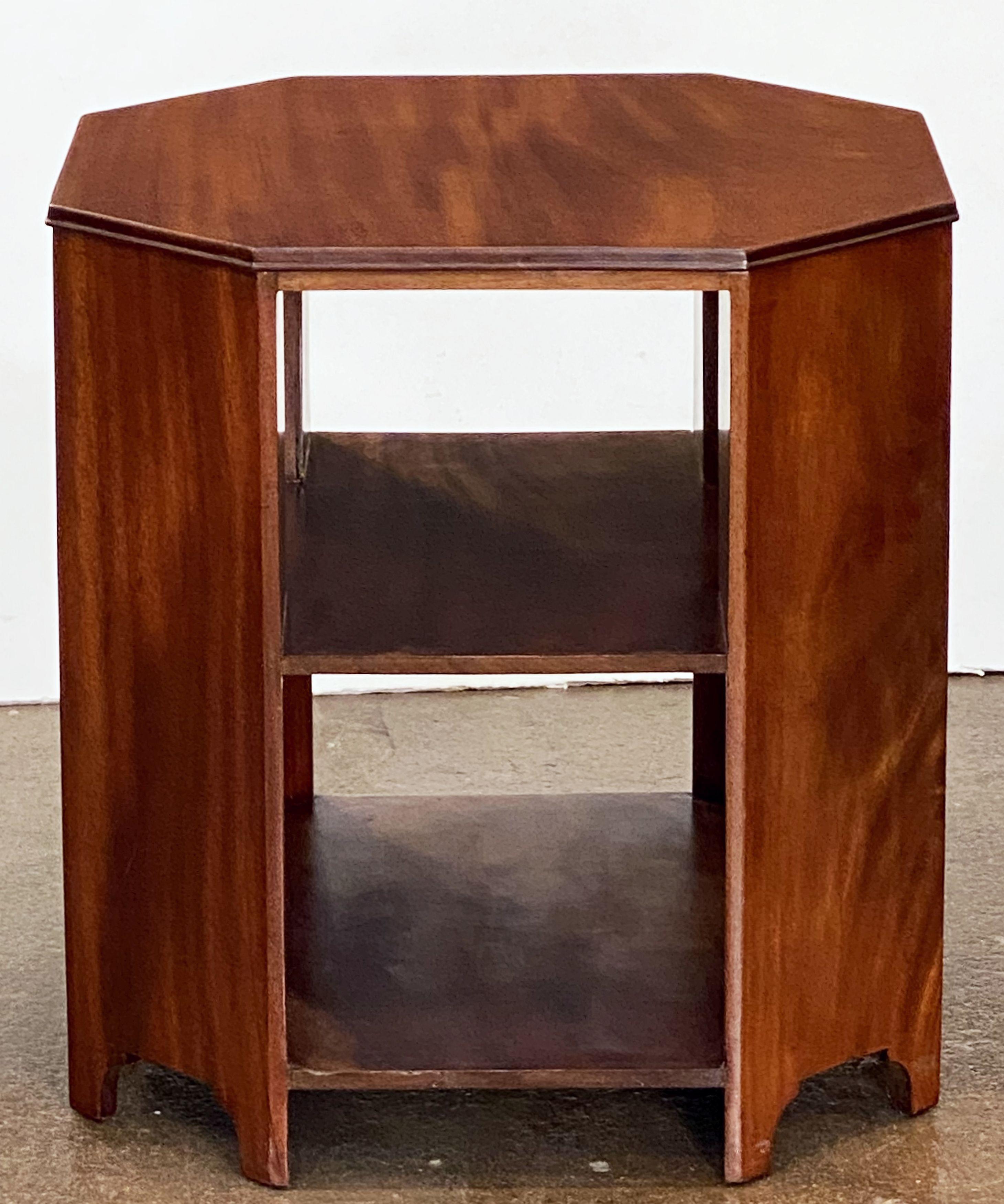 A fine English occasional or side table of mahogany in the Art Deco style, featuring a moulded octagonal top over two shelves with canted corner supports.