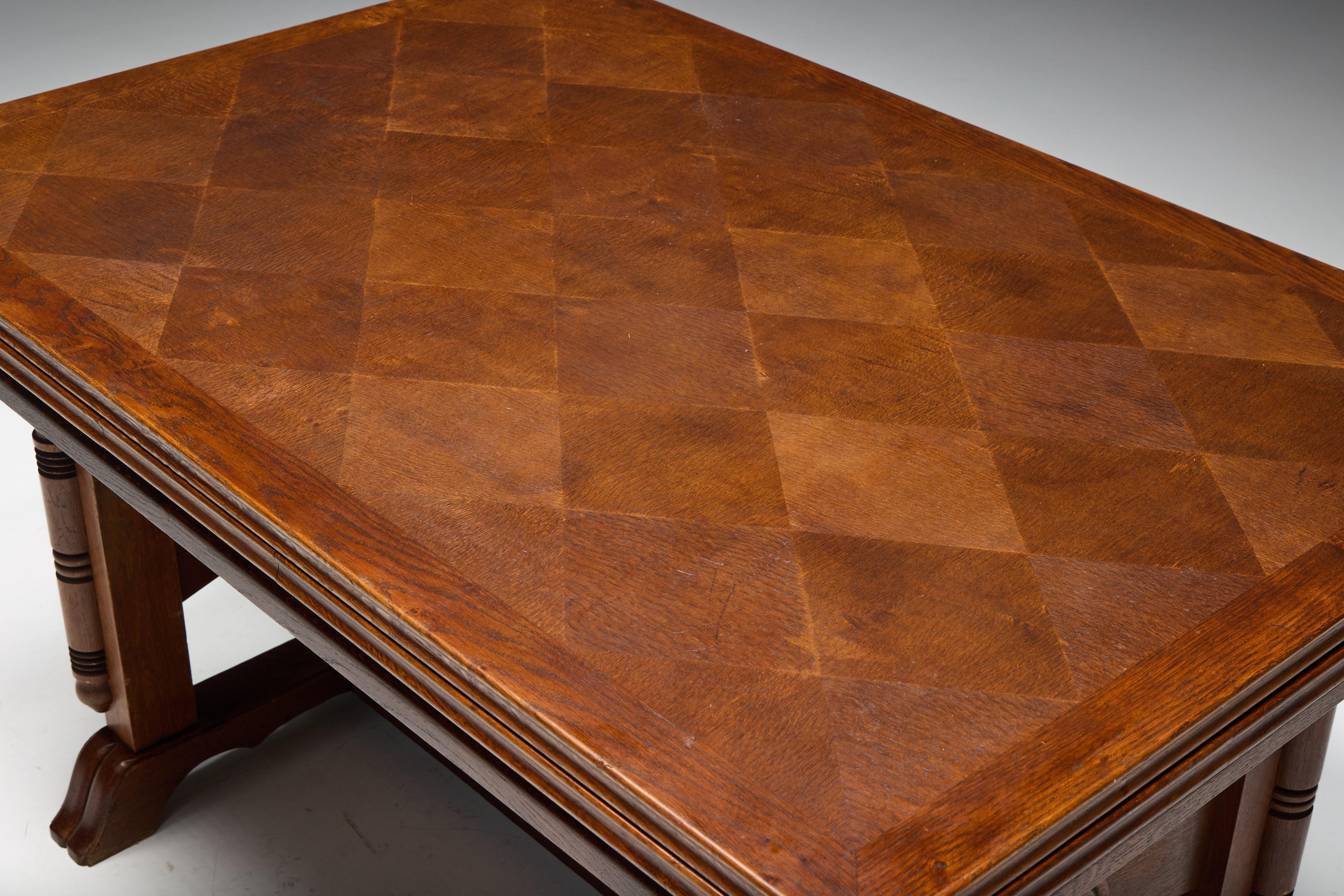This extendable dining table by Charles Dudouyt, crafted in France circa 1940s, is a masterful example of his bold yet refined design sensibility. The central tabletop features a striking diamond-patterned parquetry in warm oak, showcasing Dudouyt’s