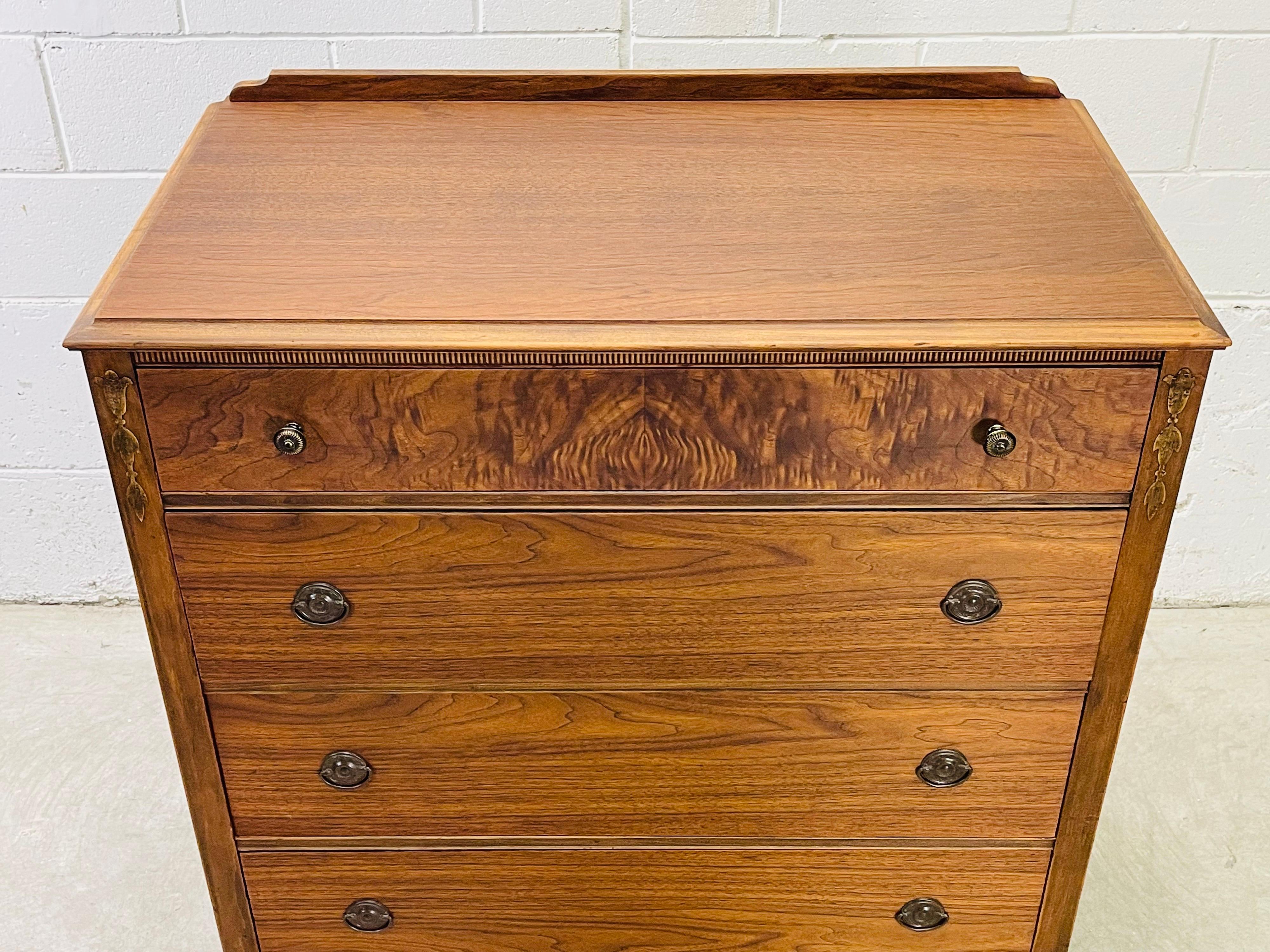 Vintage Art Deco style tall walnut wood dresser with four drawers. The top draw has a burl wood accented front. The dresser also has other decorative accents. The drawers measure 4” -7”H and the drawers interiors are oak wood. Lots of storage and a