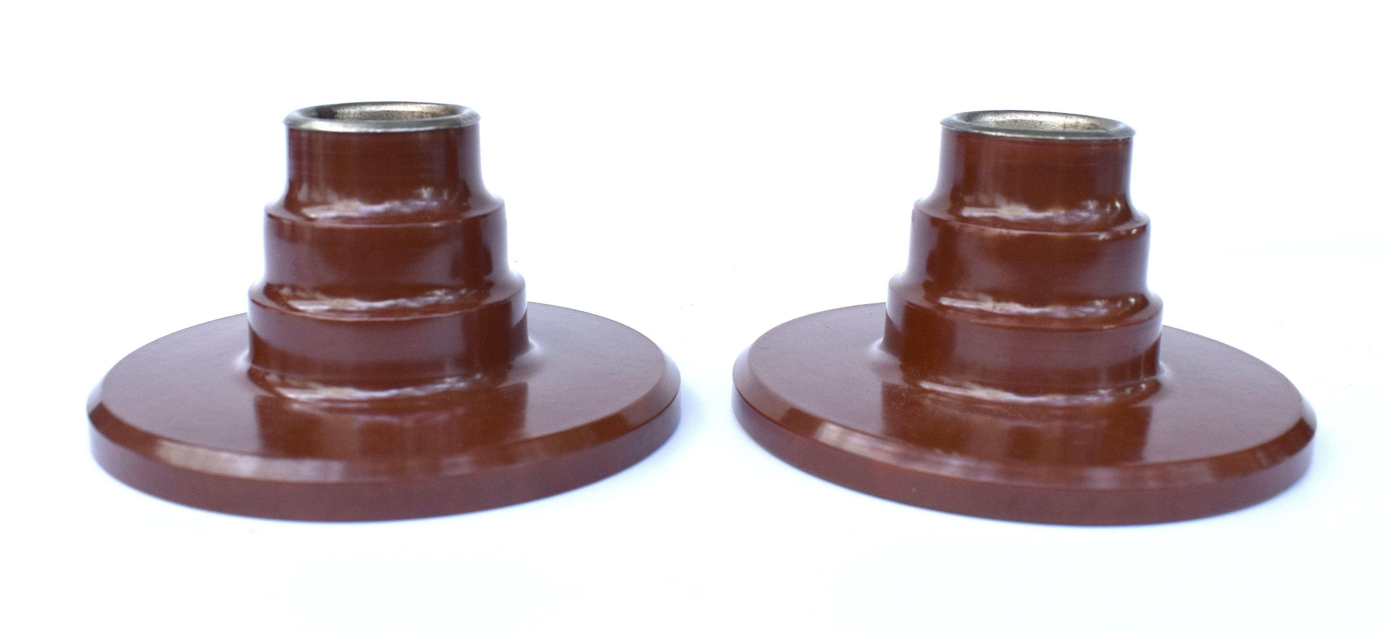 Super stylish matching pair of tan coloured bakelite candlesticks dating from the 1930's and English in origin. Excellent condition, no burn marks, chips or discolouration. Both have their original metal weighted bases and metal liner inside to