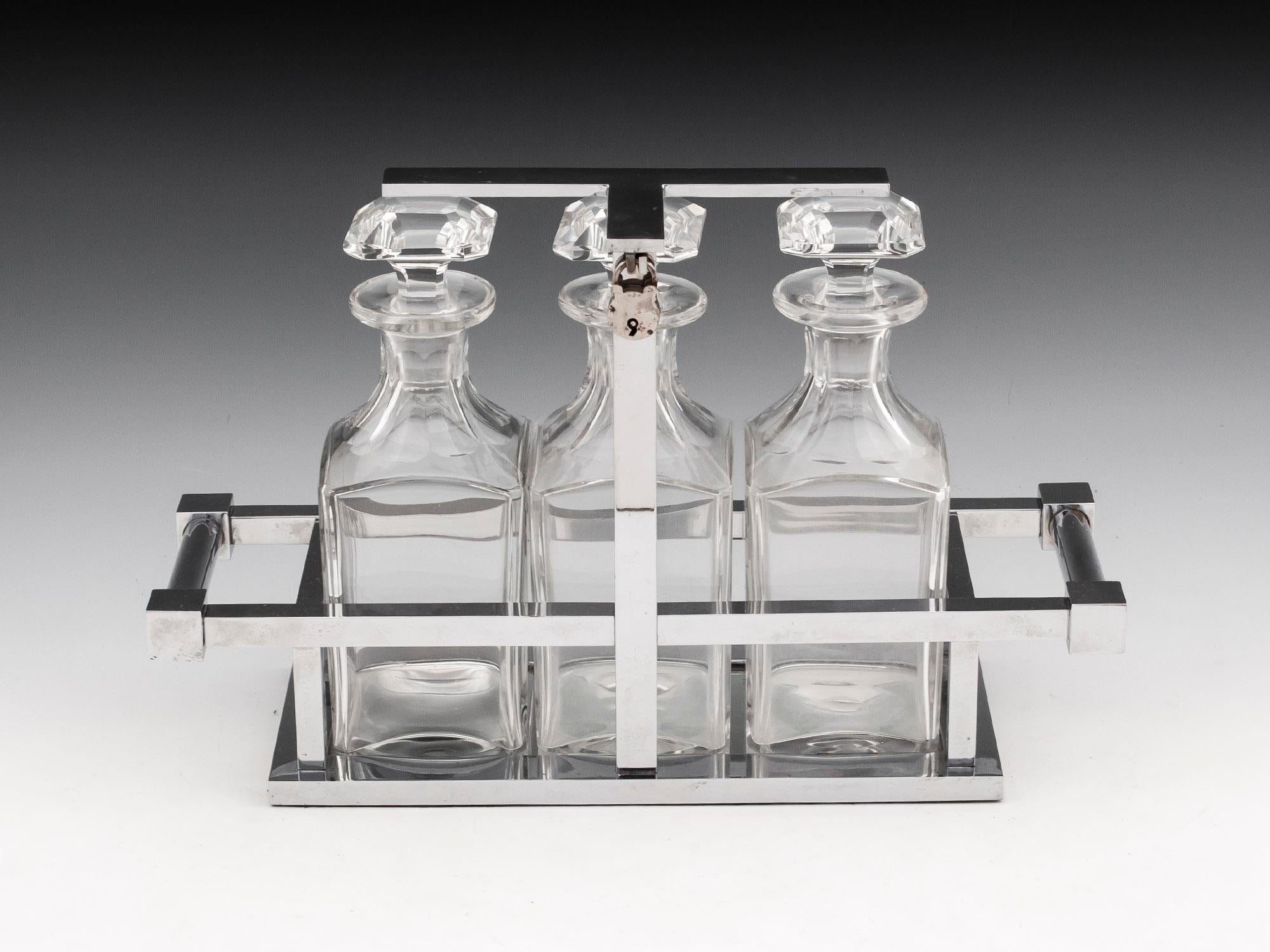 Chromium Plated Circa 1930

From our Tantalus collection, we are delighted to offer this Jacques Adnet Art Deco Tantalus. The Tantalus houses three square-cut crystal glass decanters with faceted stoppers within a Chromium plated tubular design with