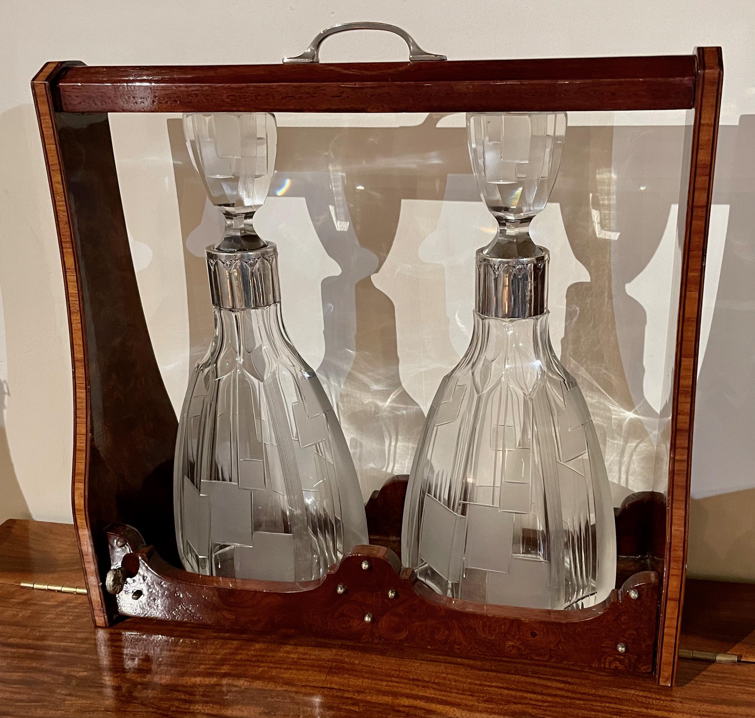 Art Deco silver-mounted tantalus set wood marquetry custom case holder with the lock and handle. Each bottle has polished silver neck support. A unique set with a very modernist approach, stunning cut crystal decanters with matching tops, all in