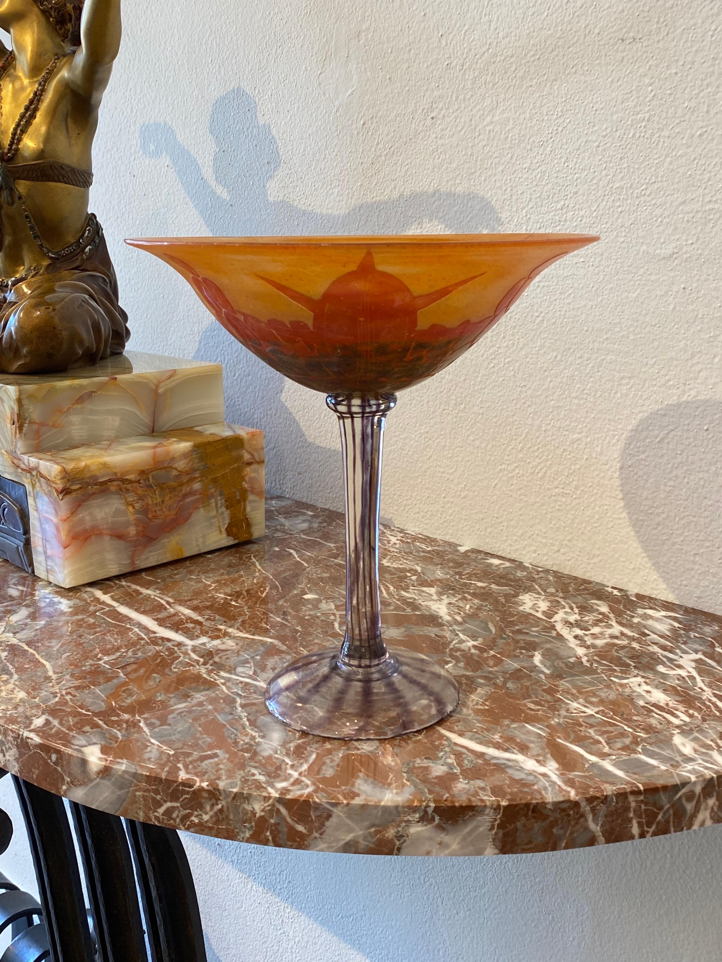 Eine kelchförmige Vase in Orange mit roten und grünen Überlagerungen.  Das Muster ist der Form einer Schildkröte nachempfunden und wird mit Säure geätzt.  Klar/Farblos aufgetragener Stiel und Fuß mit Violett gestreift.  Dieses Stück gehört zu der