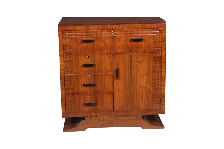 A stunning cabinet or chest commode. Drawers on one side and cabinet with shelving on the other. Sold teak with a splayed base and beveled wood trim along the sides. Replaced locks have working keys. Interior shelves on the cabinet side. Rosewood