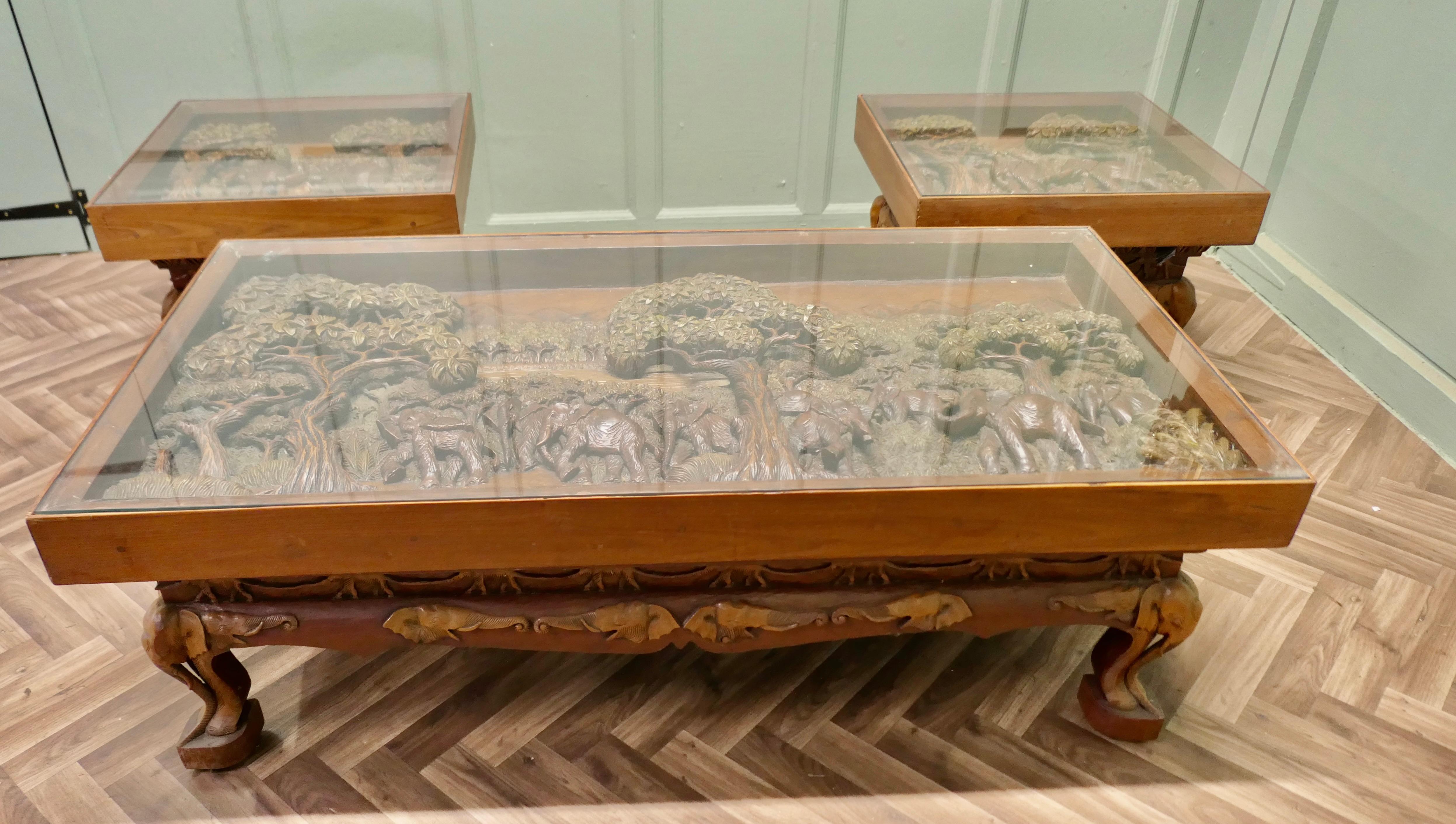Juego de Mesa de Centro Art Decó de Teca Tallada con Elefantes 

Un magnífico conjunto de mesas talladas a mano por expertos
El conjunto se compone de una mesa de centro grande y 2 mesas de centro cuadradas
Los tableros de las mesas tienen un grosor
