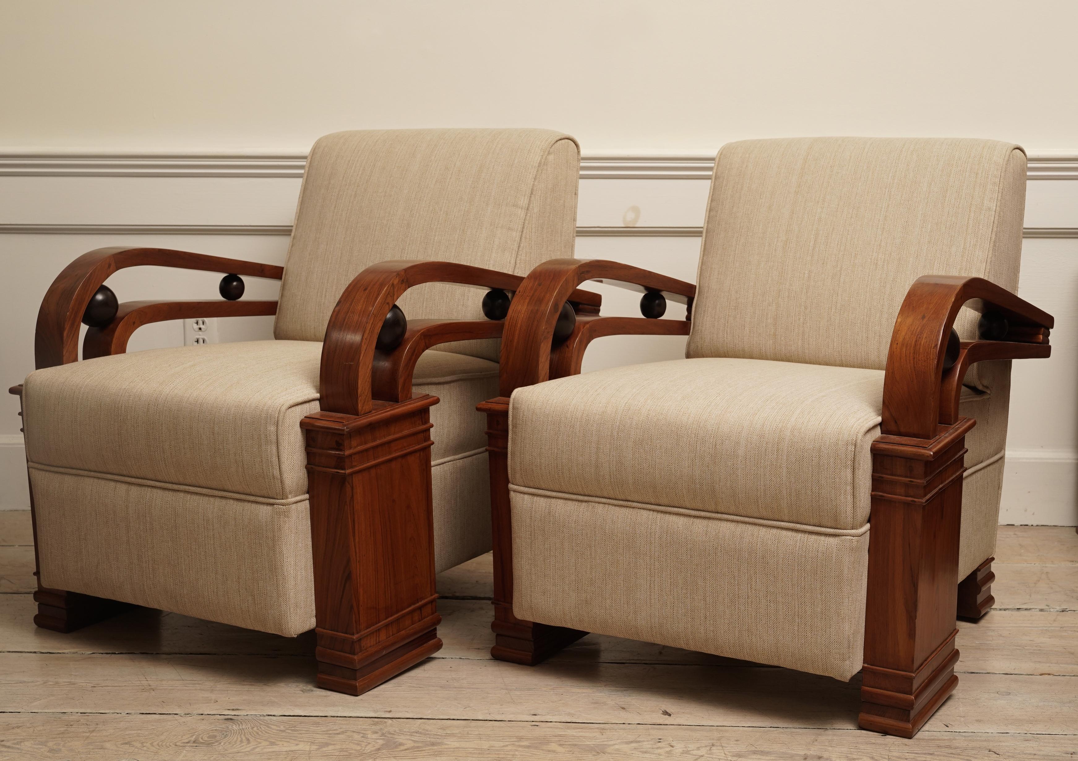 A handsome and stylish Art Deco suite comprised of a love seat and pair of club chairs. Teak wood with ebonized accents. Refinished and reupholstered in an oatmeal colored silk/linen blend. Includes four down pillows, 1930s, European. Love seat is