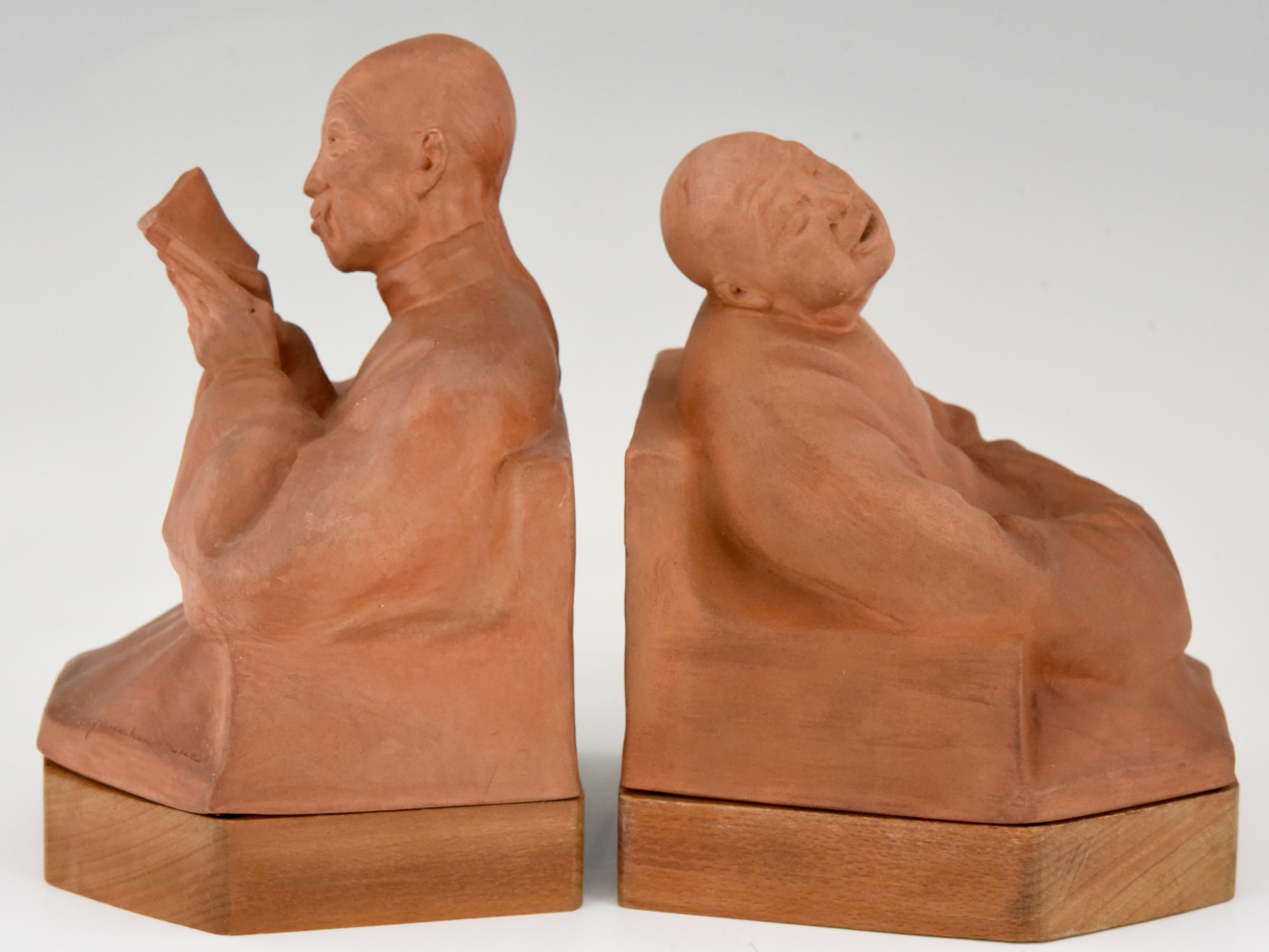 A pair of Art Deco terracotta bookends with Chinese men.
One reading the other listening by Gaston Hauchecorne. The bookends stand on a wooden base. France 1925.
“Dictionnaire des peintres, sculpteurs, dessinateurs et graveurs” ?by E. Benezit.
