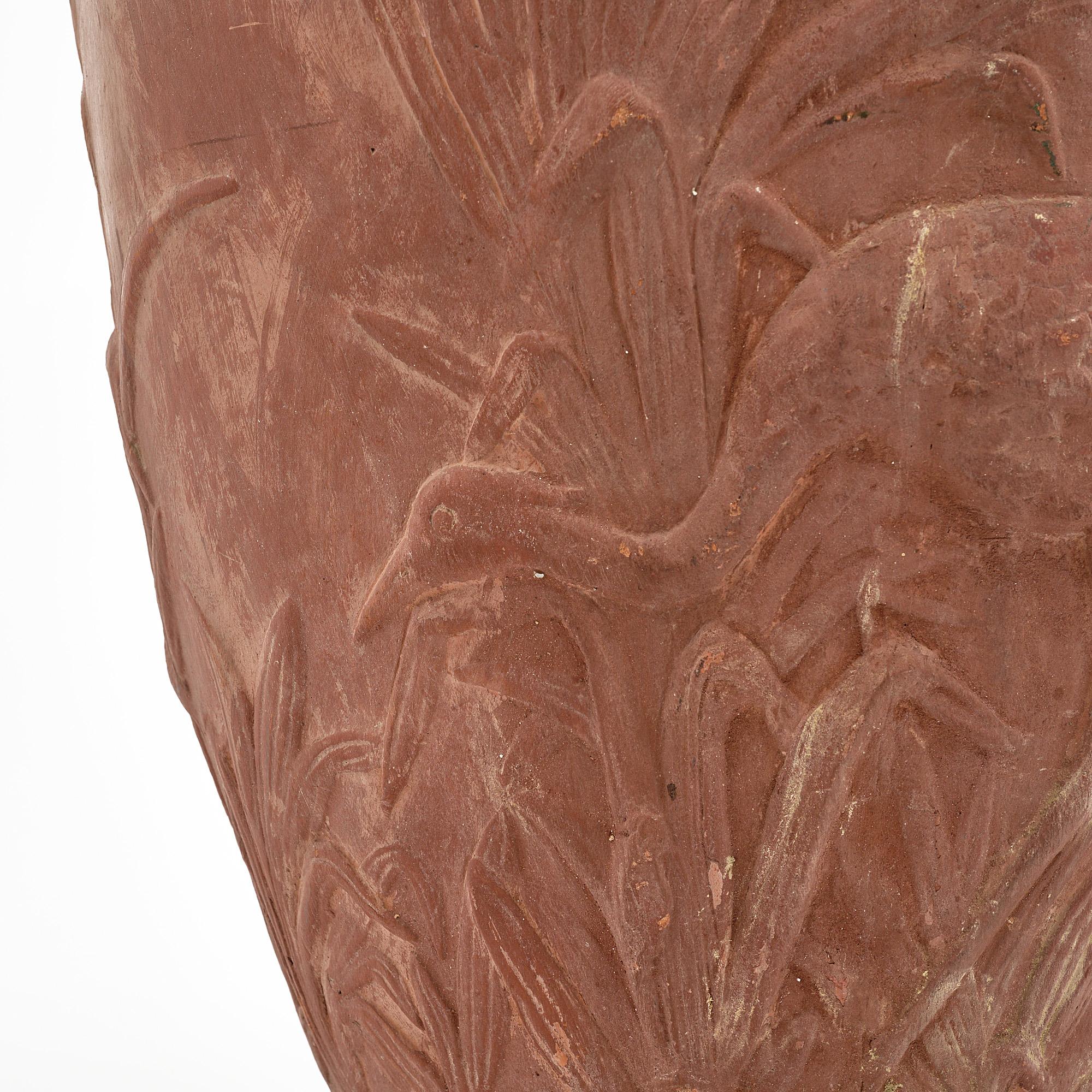 Grand vase, récipient, français, de la période Art Déco en terre cuite ciselée. Cette importante pièce de poterie à la manière de l'artiste Art déco emblématique Jean Dunand représente des hérons dans des terres marécageuses entourés de feuillage de