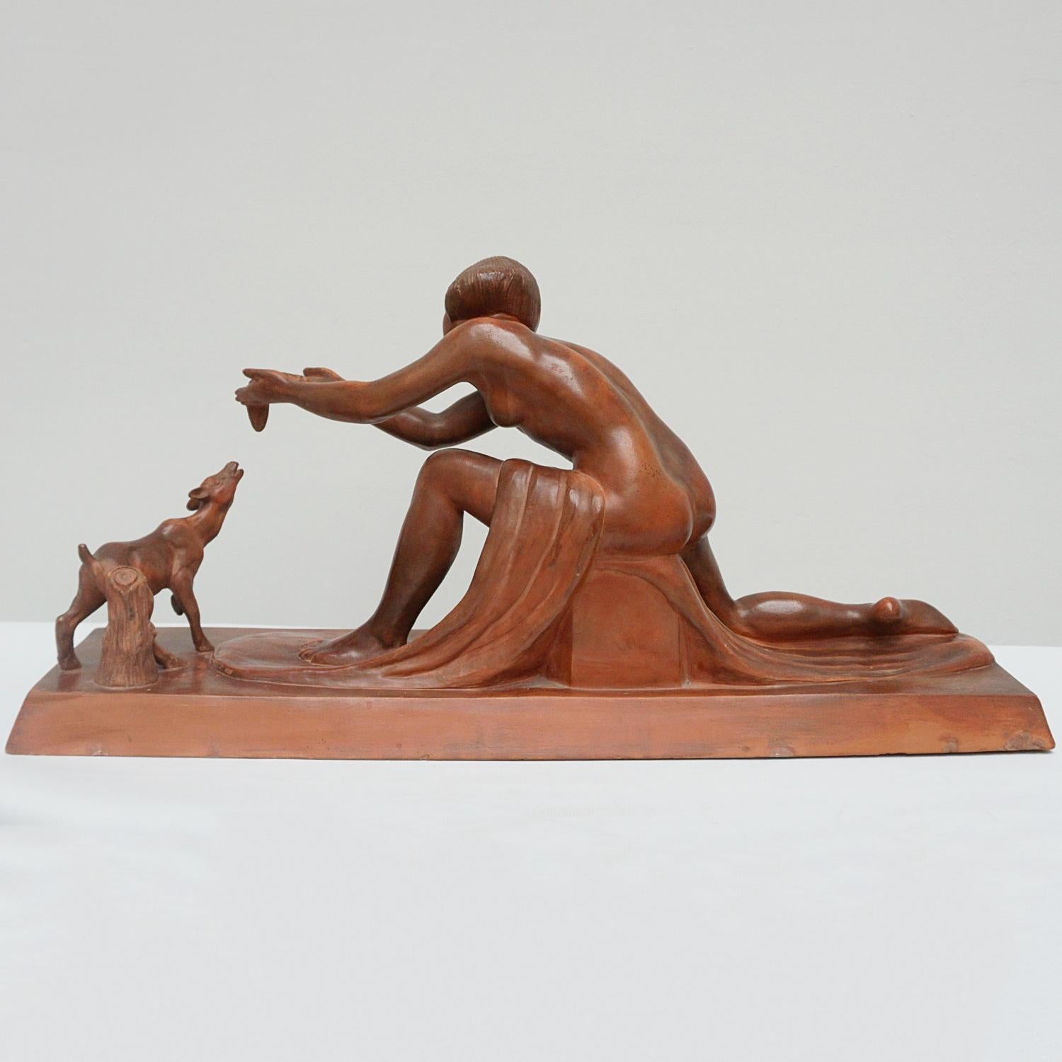 Eine Art-Deco-Terrakotta-Skulptur von Clarice Levy-Kinsbourg, die ein nacktes Mädchen darstellt, das ein junges Rehkitz füttert, wobei ihr Gewand um den Sockel drapiert ist. Signiert 