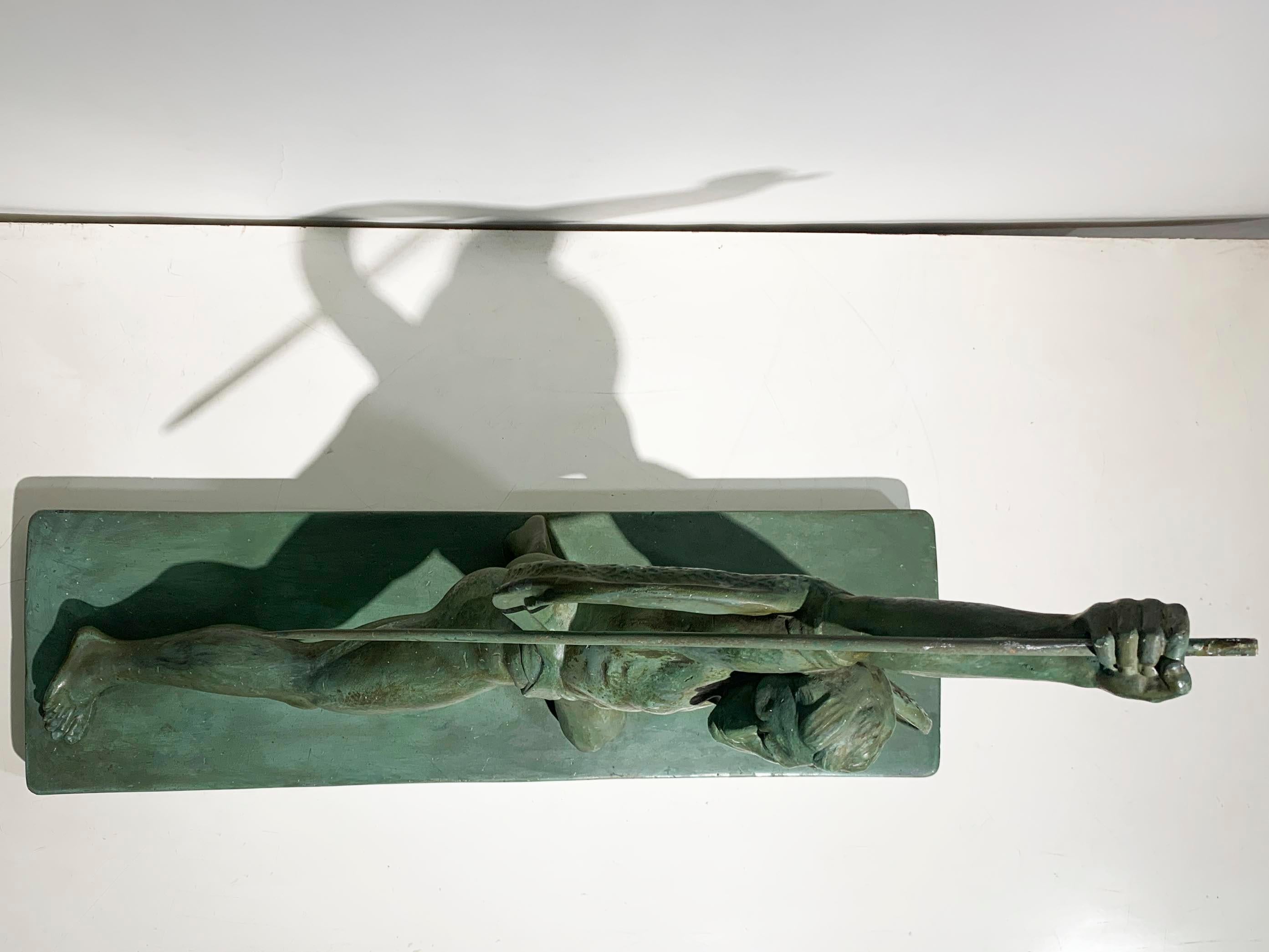 Esta escultura de Salvatore Melani representa a un guerrero dinámico y musculoso en una intensa pose preparada para la batalla. La figura se lanza hacia delante con una pierna estirada y la otra doblada, transmitiendo una fuerte sensación de