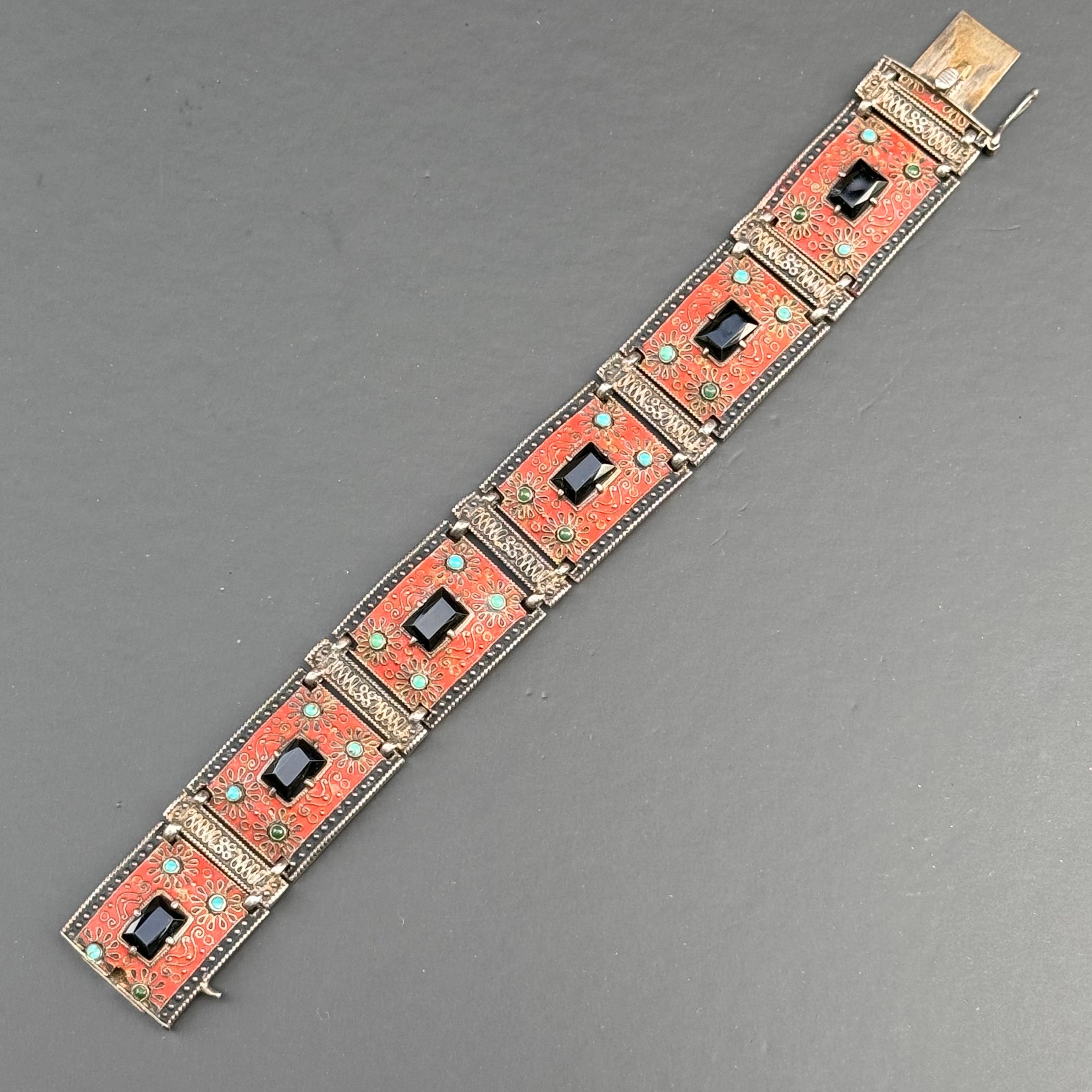 Cattura l'eleganza senza tempo dell'epoca Art Déco con questo splendido braccialetto vintage di Theodor Fahrner, un celebre designer di gioielli tedesco rinomato per la sua squisita maestria e i suoi design innovativi.

Realizzato in argento 935,