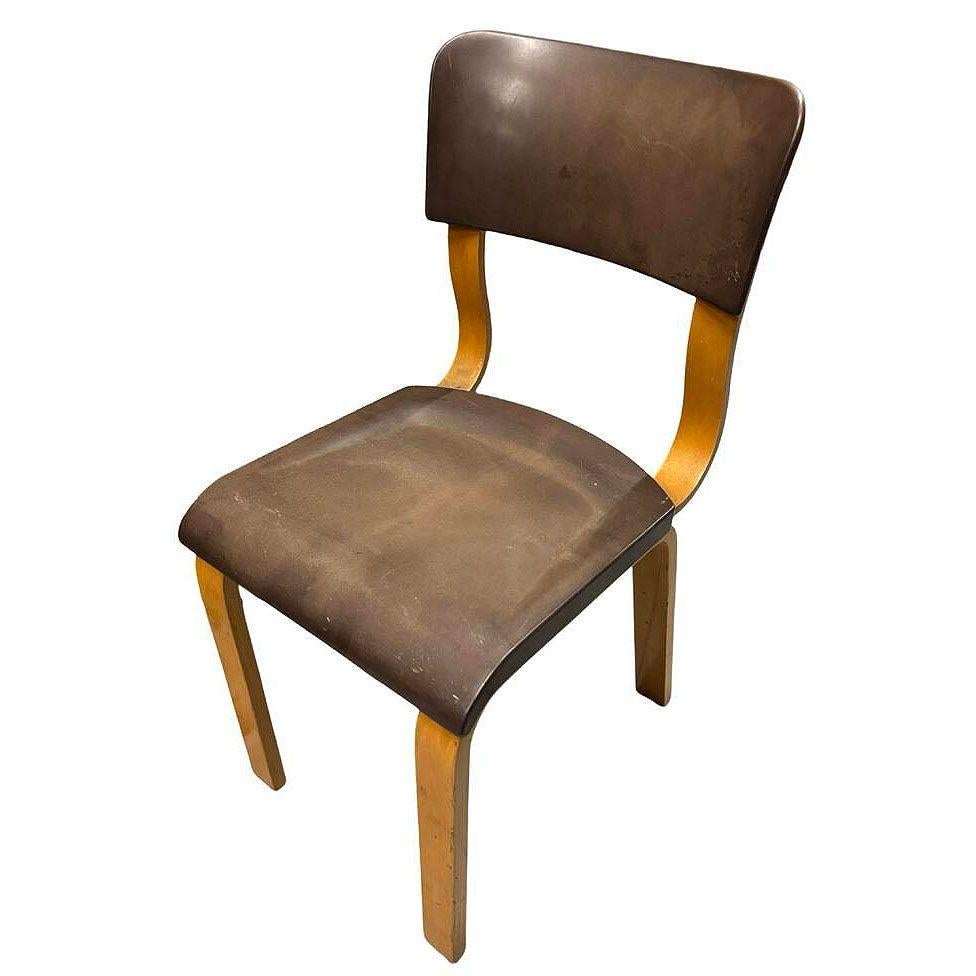 This original Thonet bentwood armchair features a Bakelite seat and backrest. The chair's bentwood beech frame is elegantly curved, showcasing the transition between Art Deco and the later Mid-century Modern design influencing later designs like the