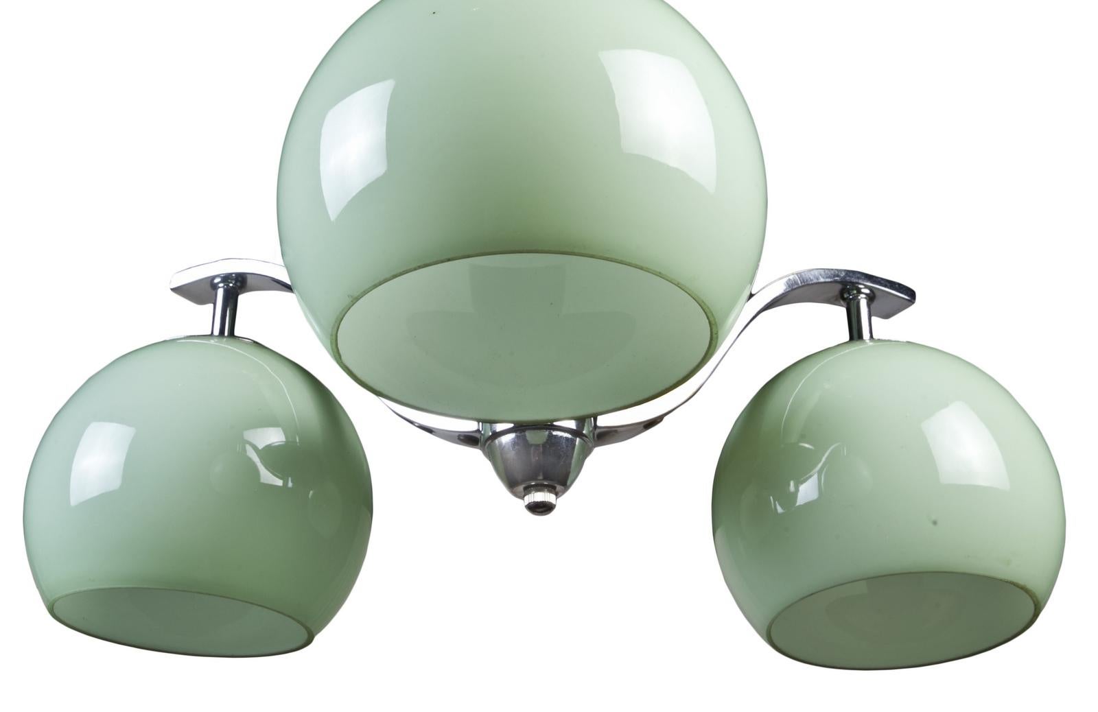 A three-arm Art Deco pendant chandelier in a lovely soft green glass. European, but rewired for American use and takes E-14 European bulbs which are easy to get. Chrome hardware and comes with chain and canopy.