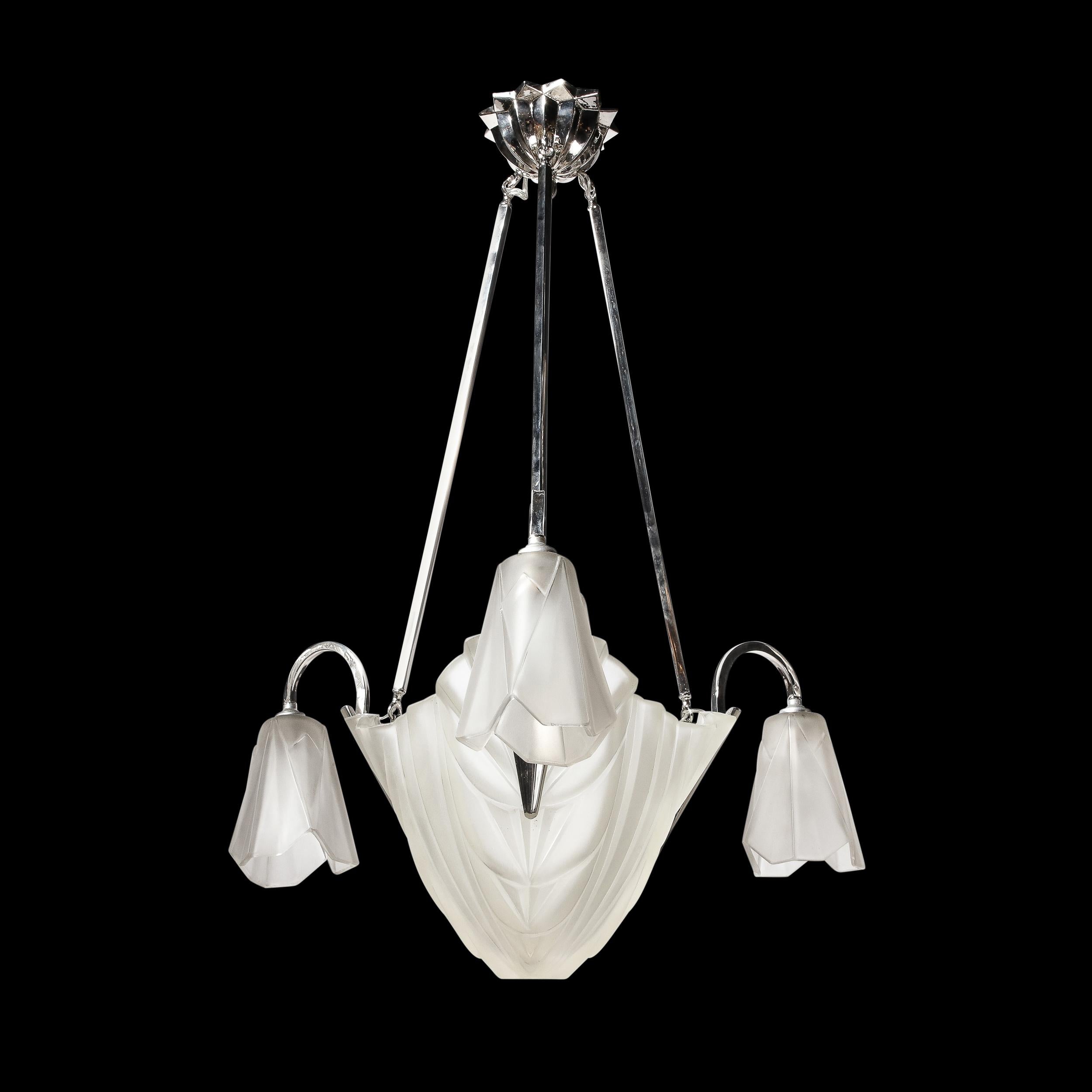 Dieser prächtige Art-Déco-Kronleuchter stammt aus Frankreich, CIRCA 1920. Er ist aus mattiertem, geformtem Glas gefertigt und mit geschwungenen, geometrischen Wolkenkratzer-Details auf den zentralen und hängenden Glasschirmen verziert. Der Baldachin