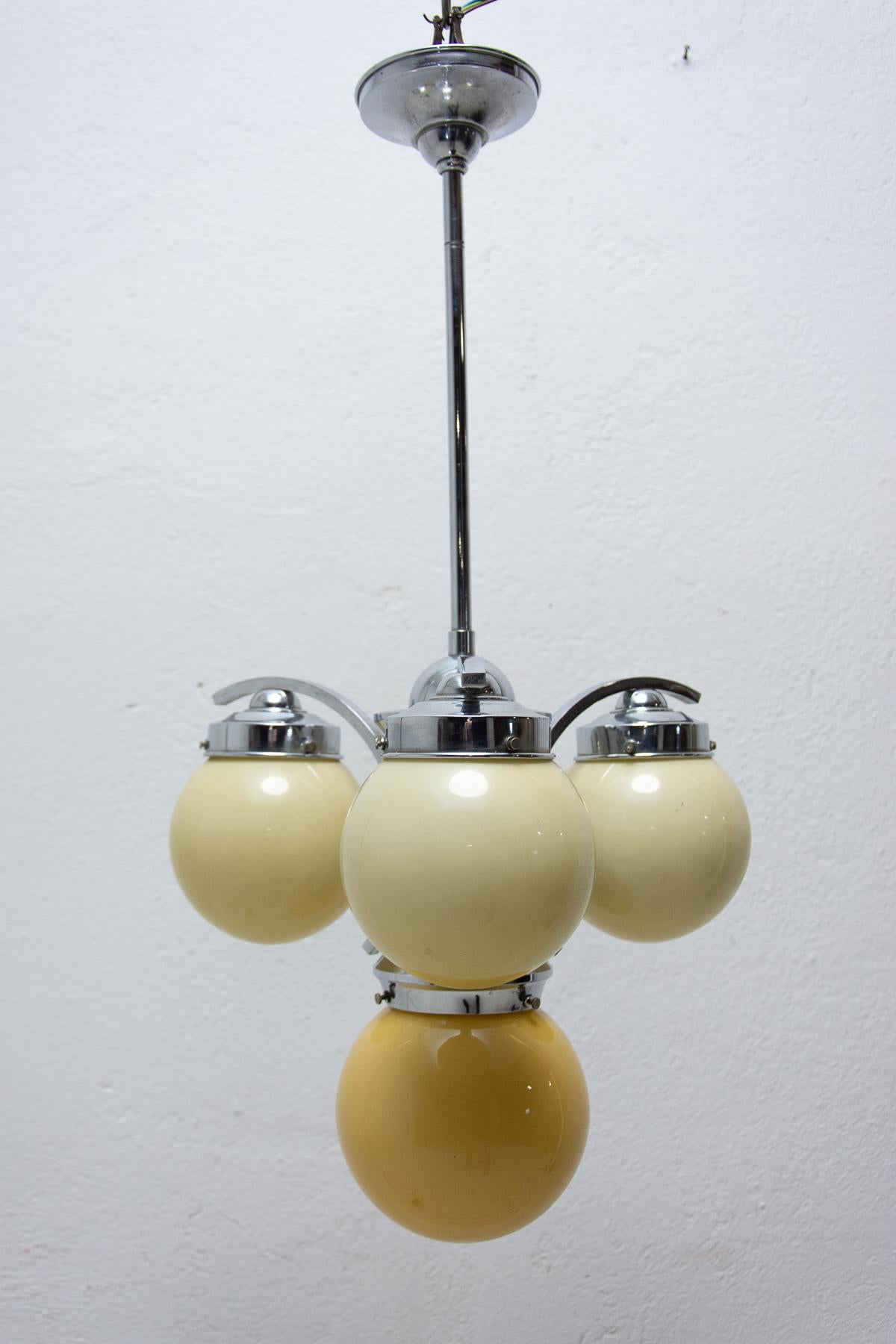 Art Deco three-armed chrome chandelier with three curved arms, shades in yellowish glass, made in the 1930´s. One ball has a slightly different shade of the yellow colour. New wiring.

Measures: Height: 70 cm

Diameter: 36 cm

Lamp shade: 32