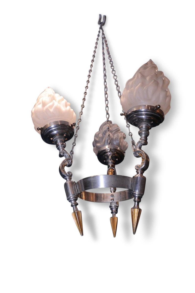 Art Deco three branch chrome and brass Gothic Electrolier, with frosted flame shades and original suspension chains.

 