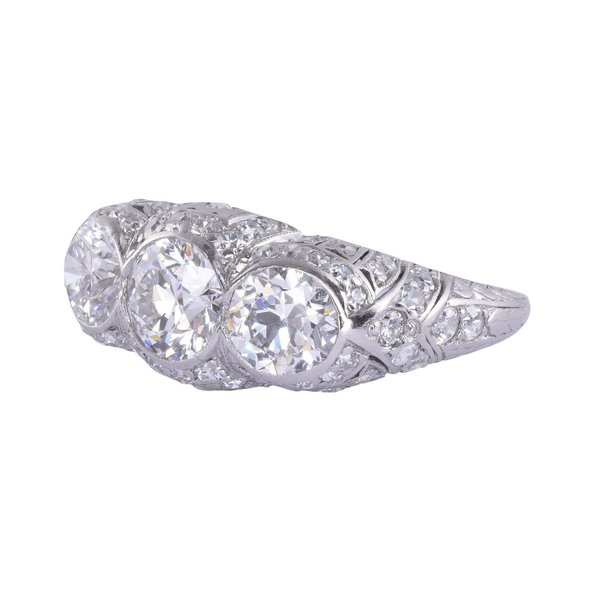 Vintage Art Deco three center diamond platinum ring, circa 1930. This Art Deco platinum ring features three bezel set center diamonds, including a .95 carat VS1 G, a .66 carat VS2 H, and a .68 carat VS2 H. There are also 68 accent diamonds including