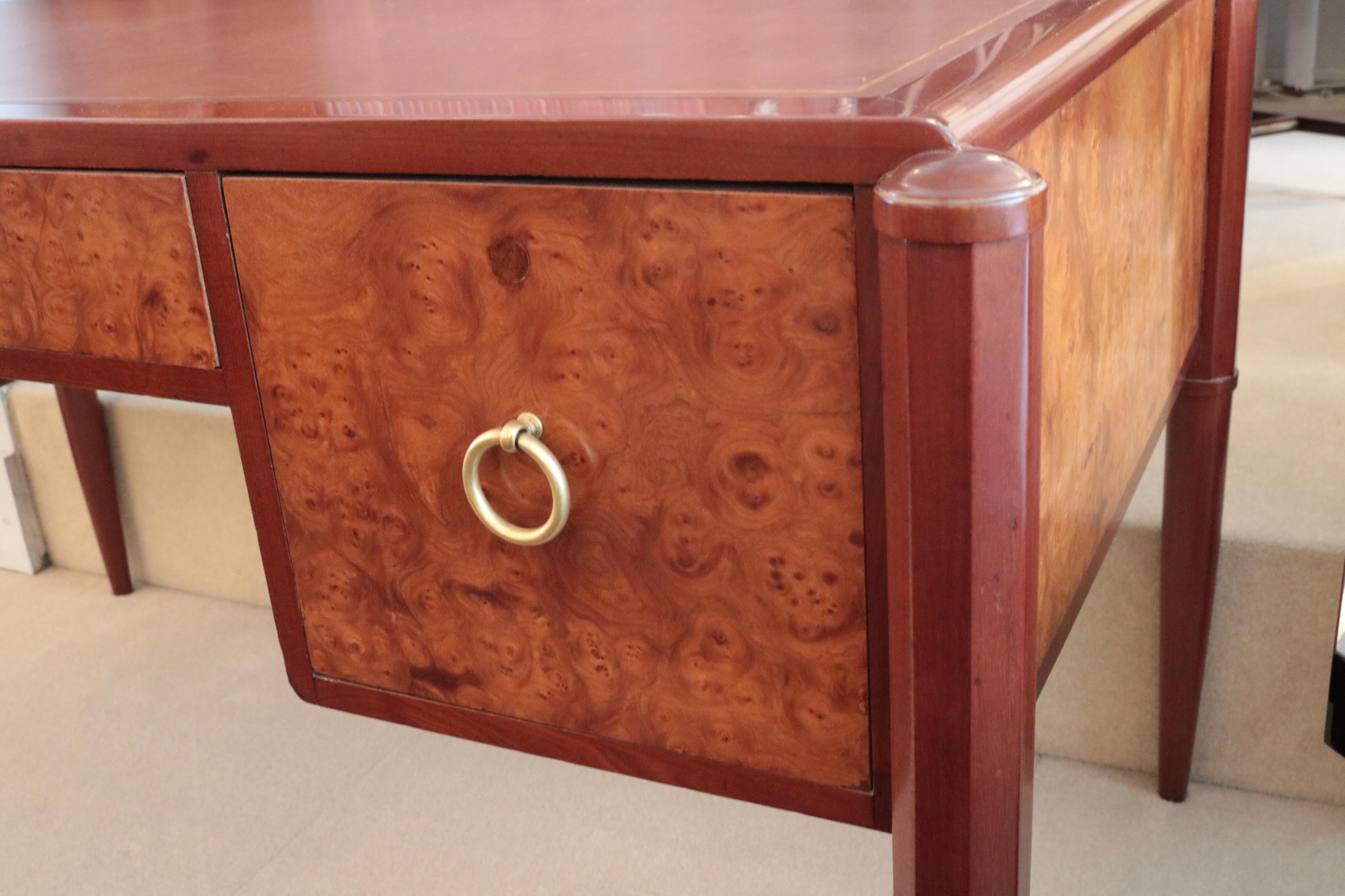 An Art Deco desk.
Mahogany and birch burl with patinated bronze pulls 
and leather top with gold tooling.
 