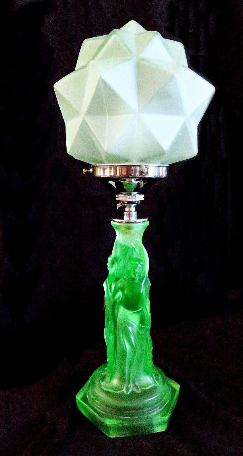 For your consideration is this tall and very elegant and original 1930s Art Deco three graces uranium glass table lamp. Features three semi nude females encircling to create the column of the lamp with a segmented glass shade. The green coloured