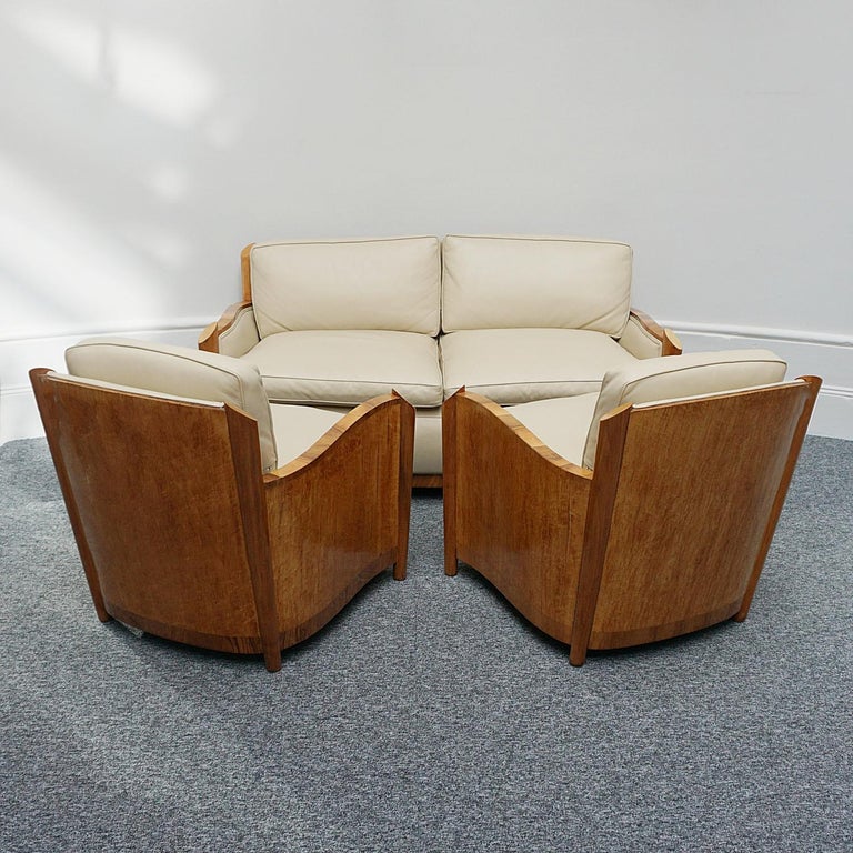 An Art Deco three piece suite by Maurice Adams. bird’s-eye maple veneered to the sides and back with figured walnut banding. Cream leather upholstery. 

Dimensions: Sofa H 76cm W 160cm D 94cm, Chair H 77cm W 77cm D 78cm

Origin: English

Date: