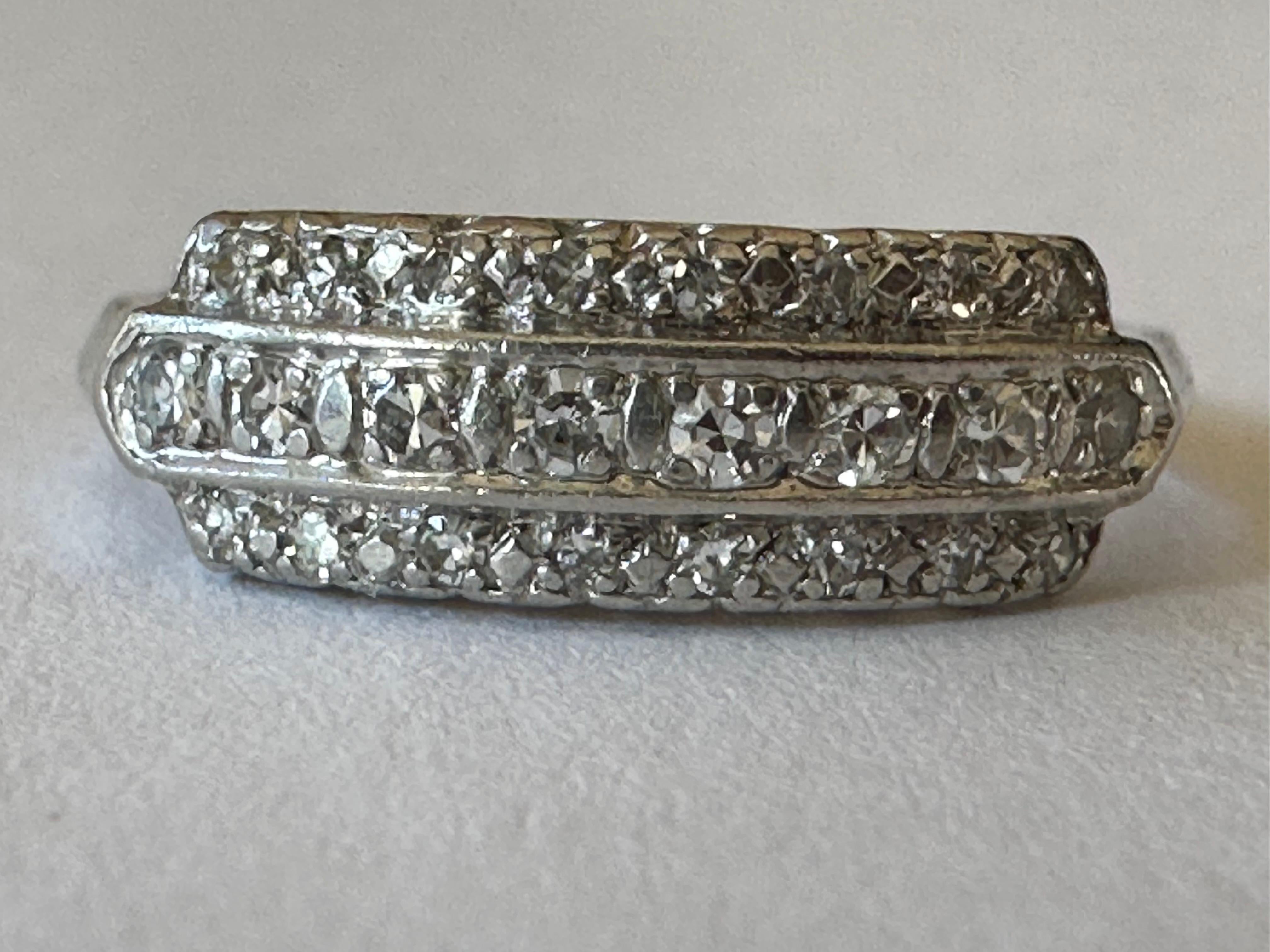 Three rows of twenty-four closely set bright-white single-cut diamonds, together weighing approximately 0.50 carats, F color, VS clarity, shimmer across the top half of this classic, gently domed band ring. Crafted in platinum. Circa 1920s. 