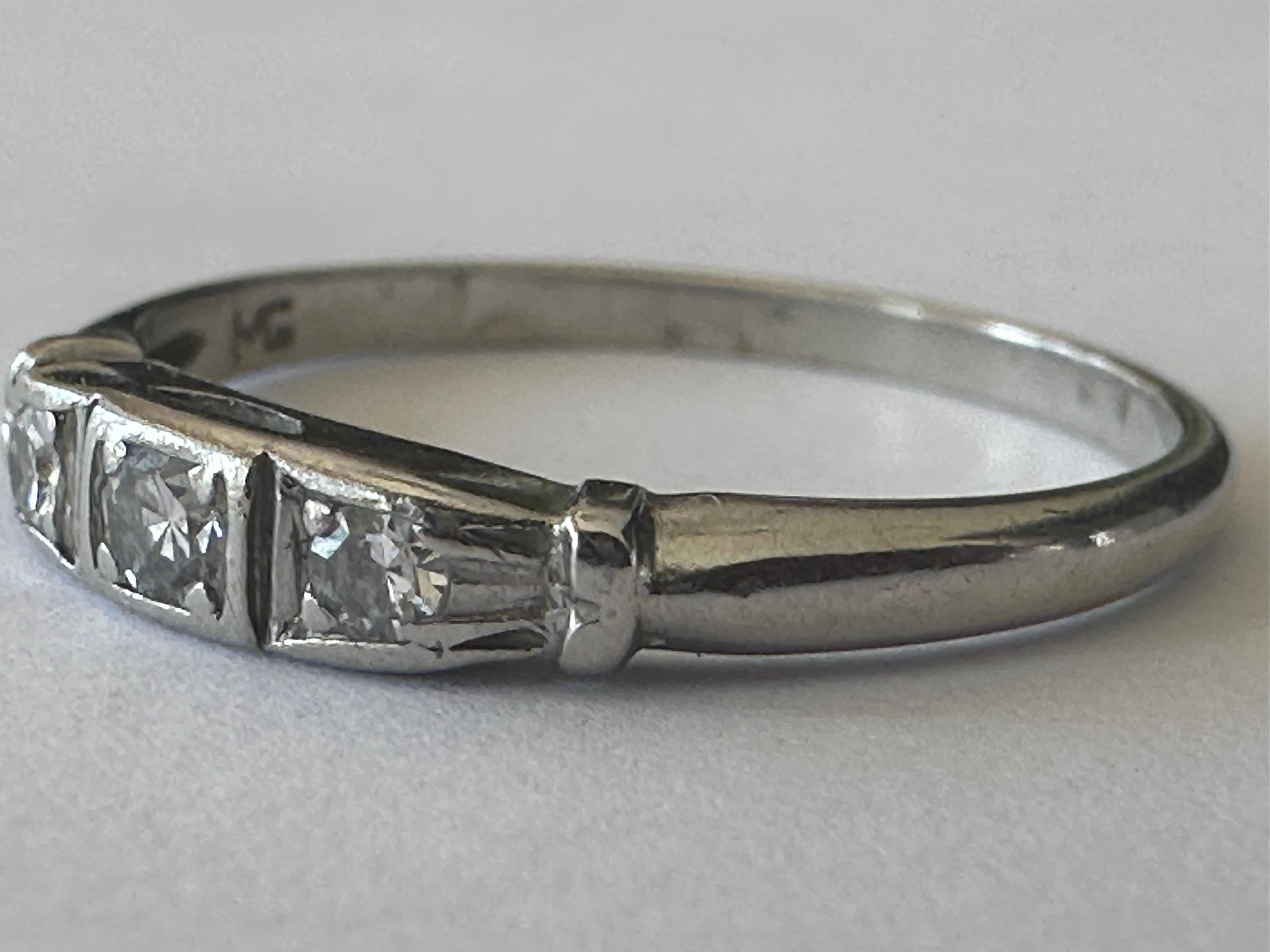 Three single-cut diamonds totaling approximately 0.08 carats F color VS clarity shimmer across the top of this classic Art Deco band crafted in platinum. The width of the top of the band measures 3mm. 