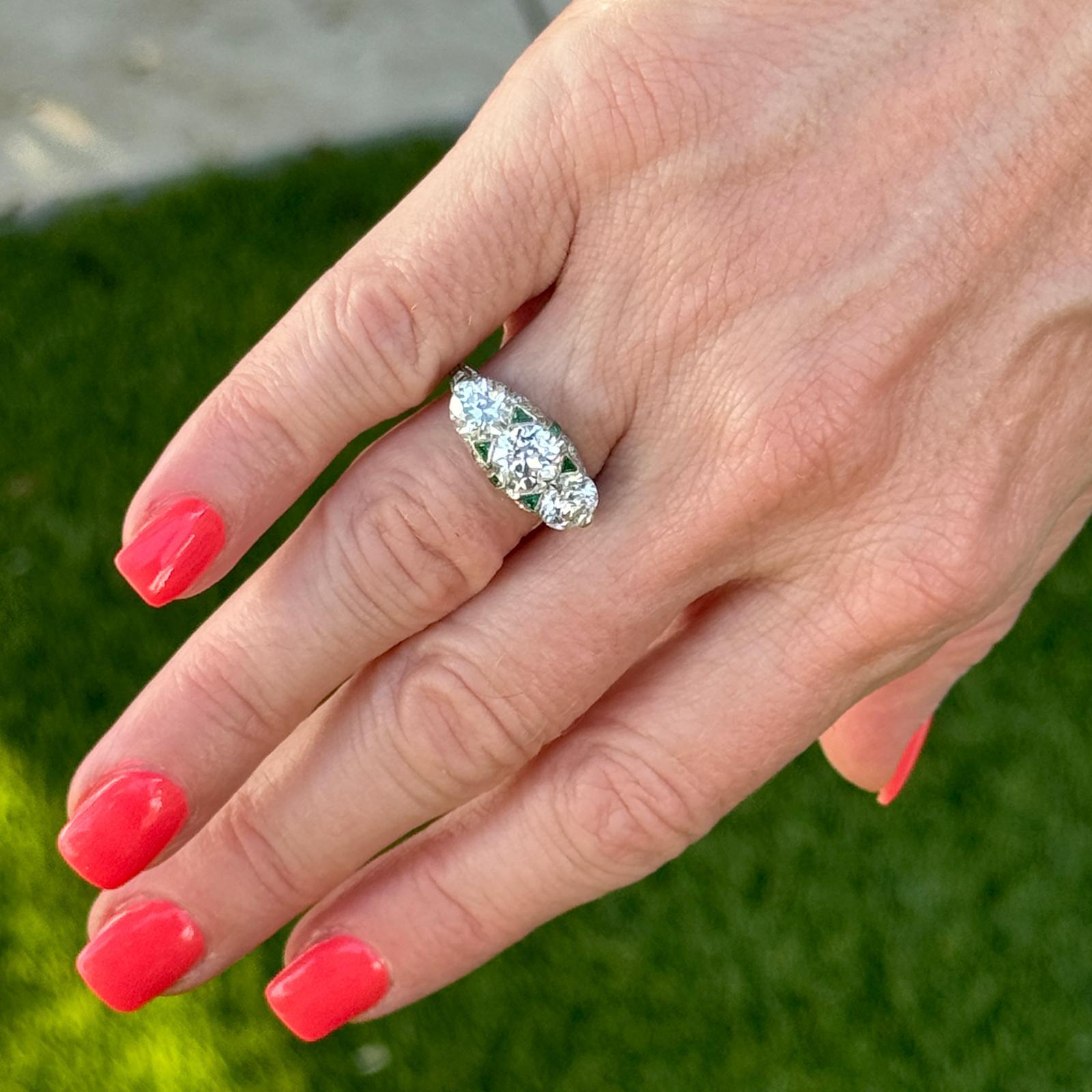 This breathtaking Art Deco ring is a magnificent display of vintage elegance and exceptional craftsmanship, crafted in luxurious platinum. The ring features a classic three-stone design, with three Old European Cut diamonds as the central focus.